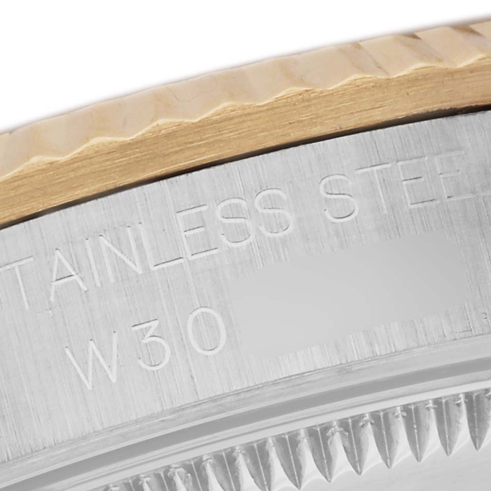 The image shows a close-up of the stainless steel case back and fluted bezel of a Mid-Size Rolex watch.