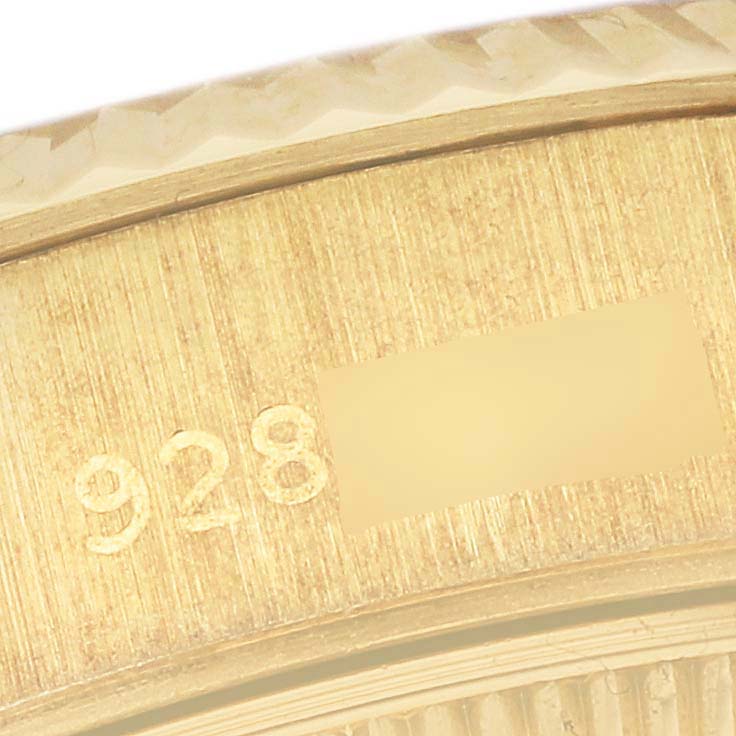 This close-up image shows the engraved serial number and part of the bezel of the Rolex President 69178 Women's Yellow Gold White Dial 69178 Women's Yellow Gold White Dial model watch.