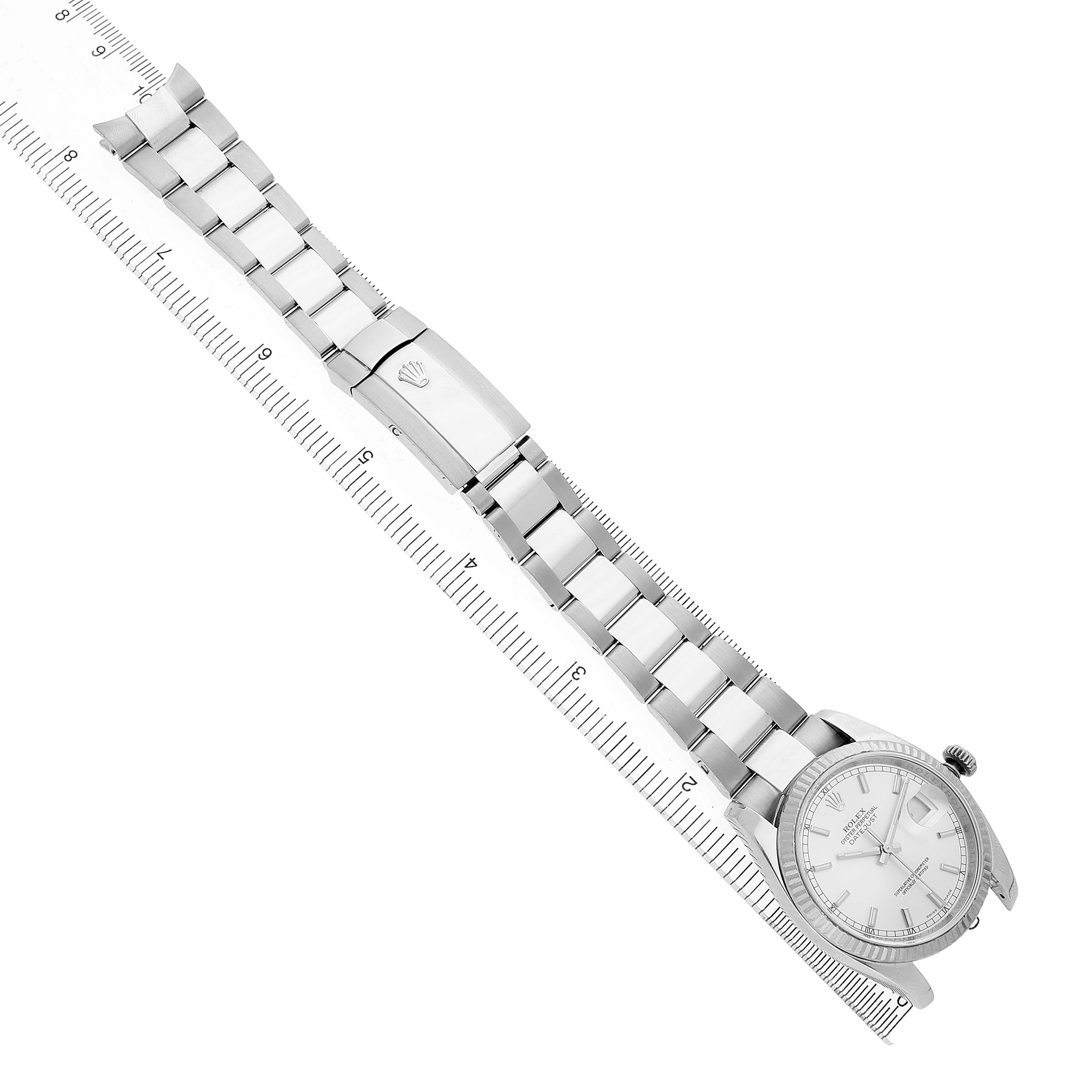 The Rolex Datejust 116234 Men's Stainless Steel Silver Dial watch is shown from a top-down angle, displaying the bracelet, clasp, and watch face alongside a ruler.