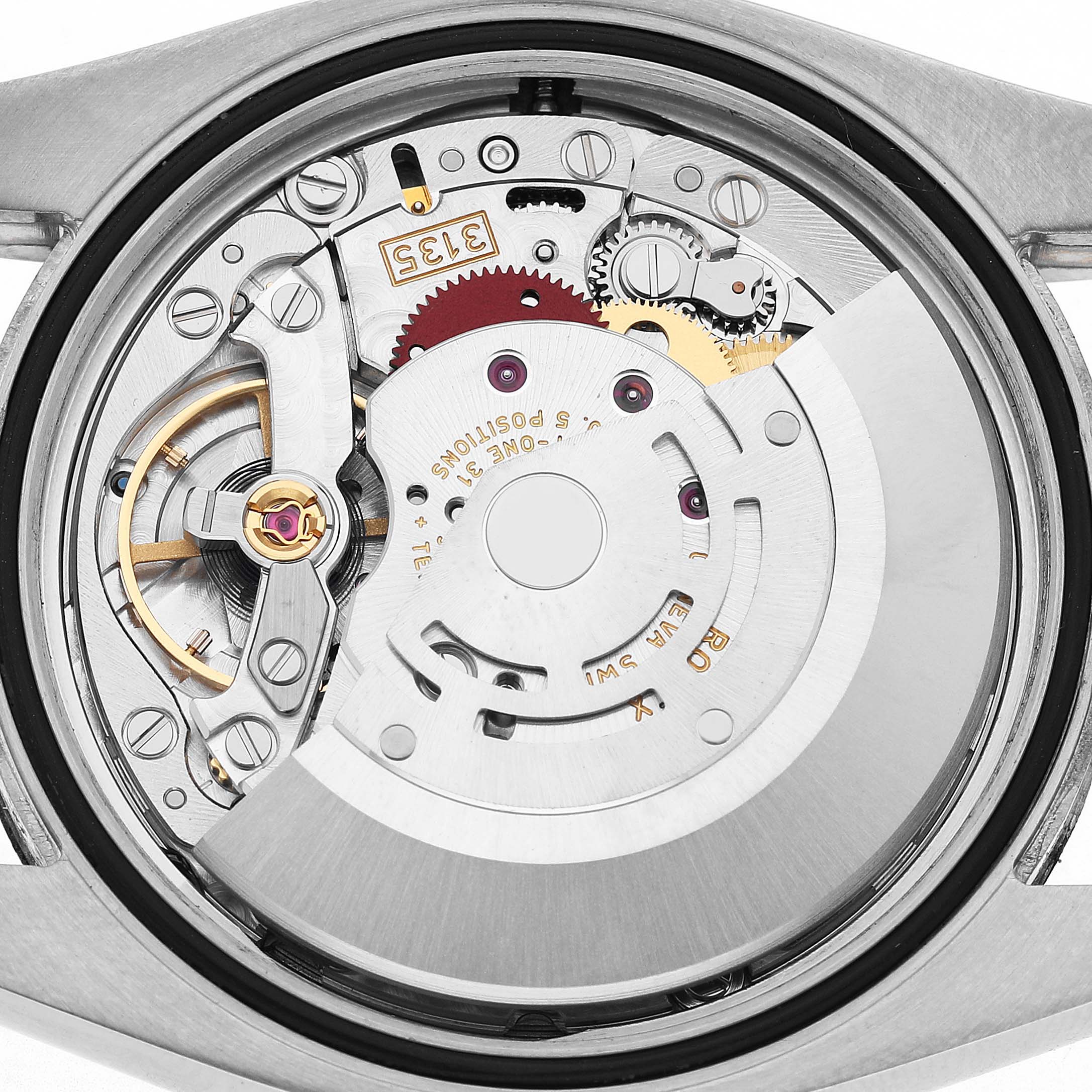 The image shows the movement mechanism of a Rolex Datejust 116234 Men's Stainless Steel Silver Dial watch from the back, highlighting the rotor and intricate gears.