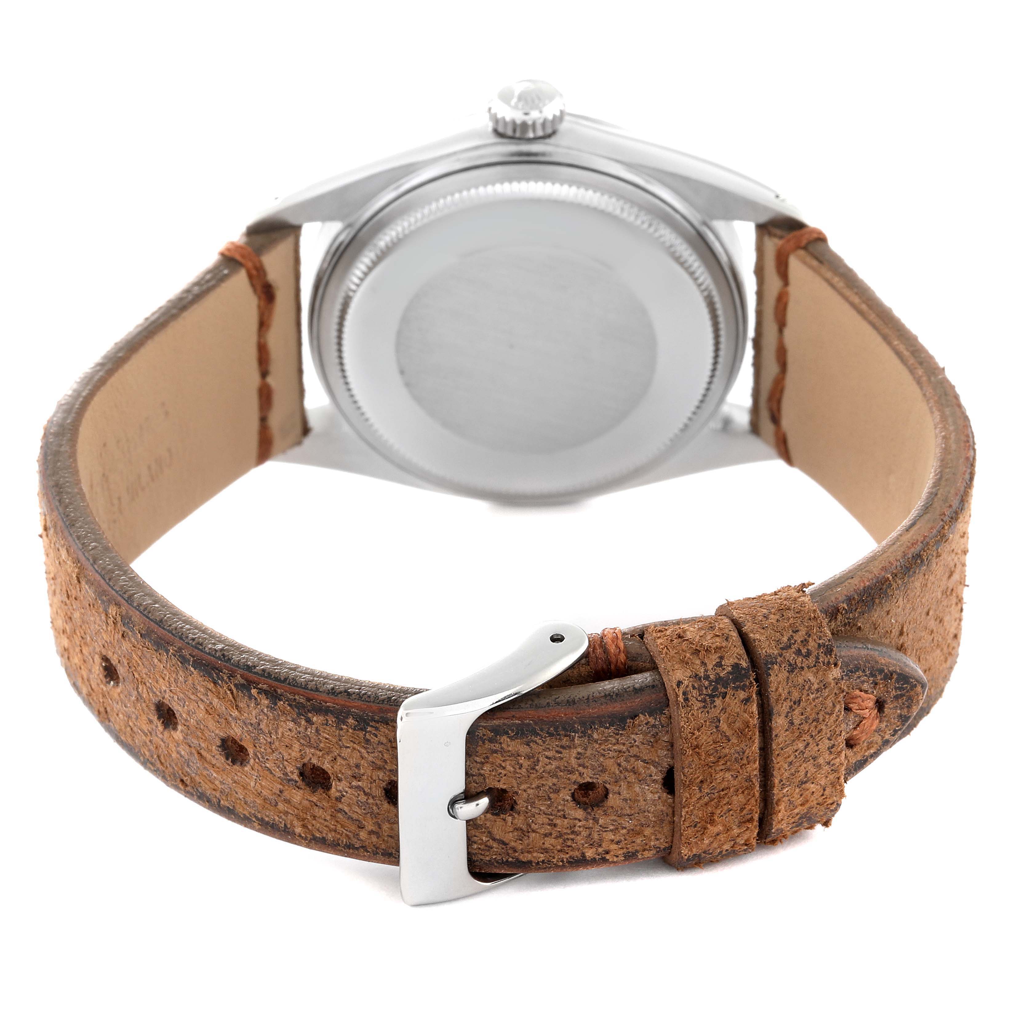 The image shows the back view of a Rolex Vintage Collection 1601 Men's Stainless Steel Silver Dial 1601 Men's Stainless Steel Silver Dial watch, highlighting its metal case and distressed leather strap with a buckle.