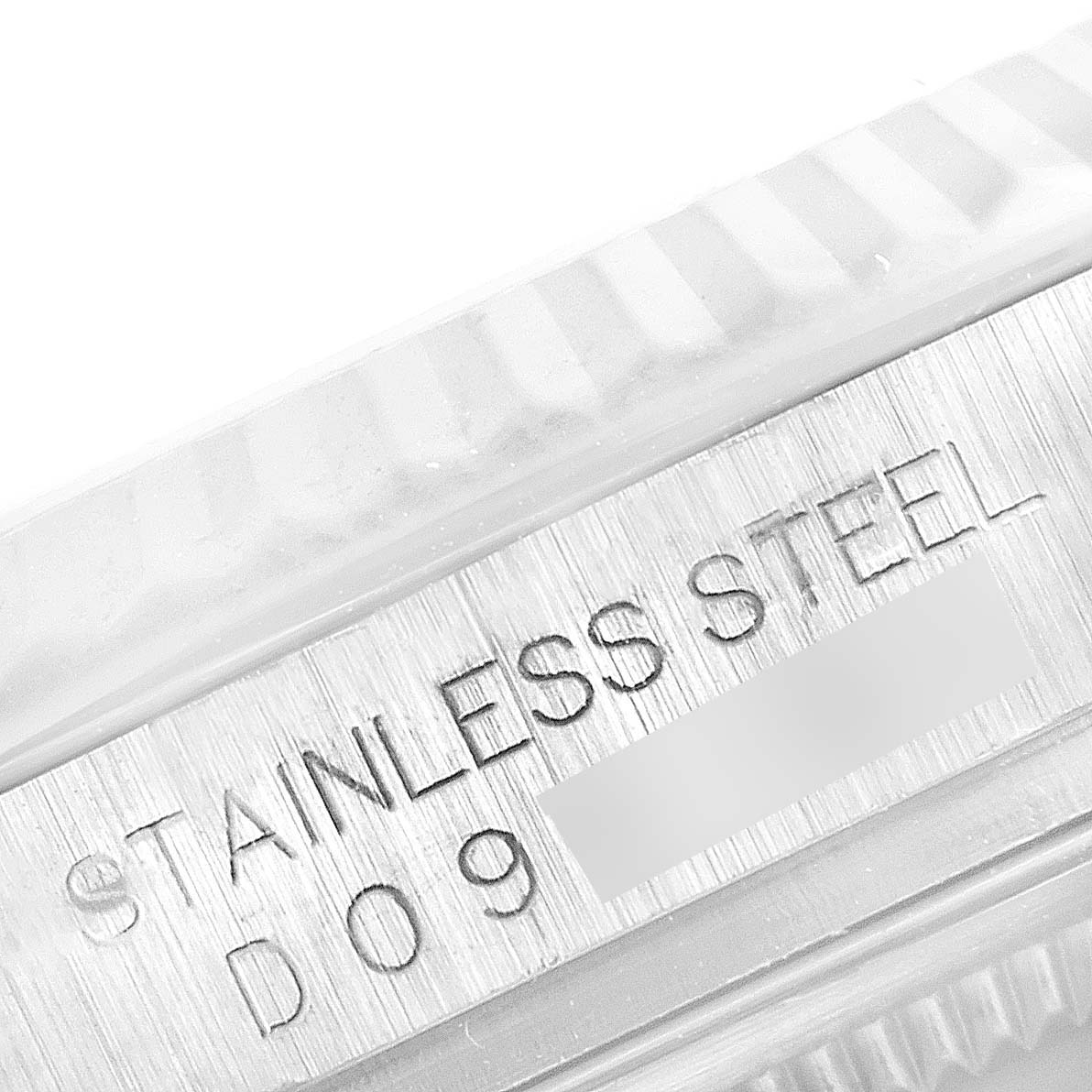 This close-up image shows the engraved "Stainless Steel" text on the case of a Rolex Datejust 116234 Men's Stainless Steel Black Dial 116234 Men's Stainless Steel Black Dial watch.