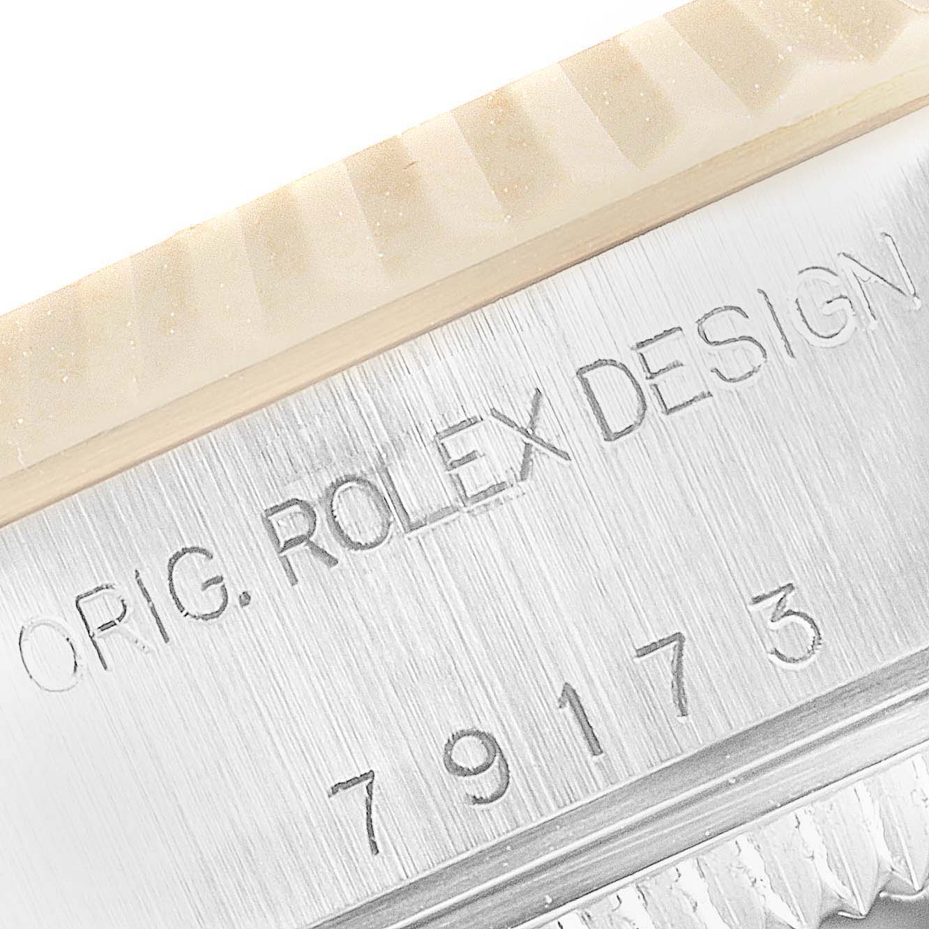 The image shows a close-up of a Rolex Datejust 79173 Women's Steel and Gold (two tone) Mother of Pearl Dial 79173 Women's Steel and Gold (two tone) Mother of Pearl Dial model, focusing on the watch's case, engraved with "ORIG. ROLEX DESIGN" and "79173."