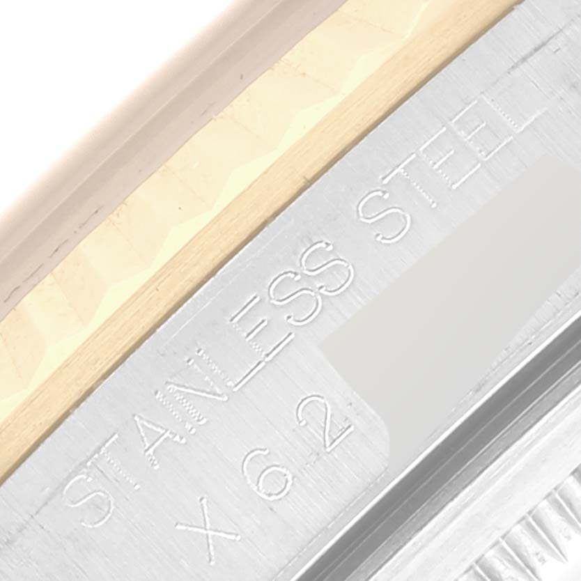 This close-up image of a Rolex Datejust 16233 Men's Steel and Gold (two tone) Grey Dial 16233 Men's Steel and Gold (two tone) Grey Dial watch shows part of the case with engraved serial numbers and "STAINLESS STEEL" markings.