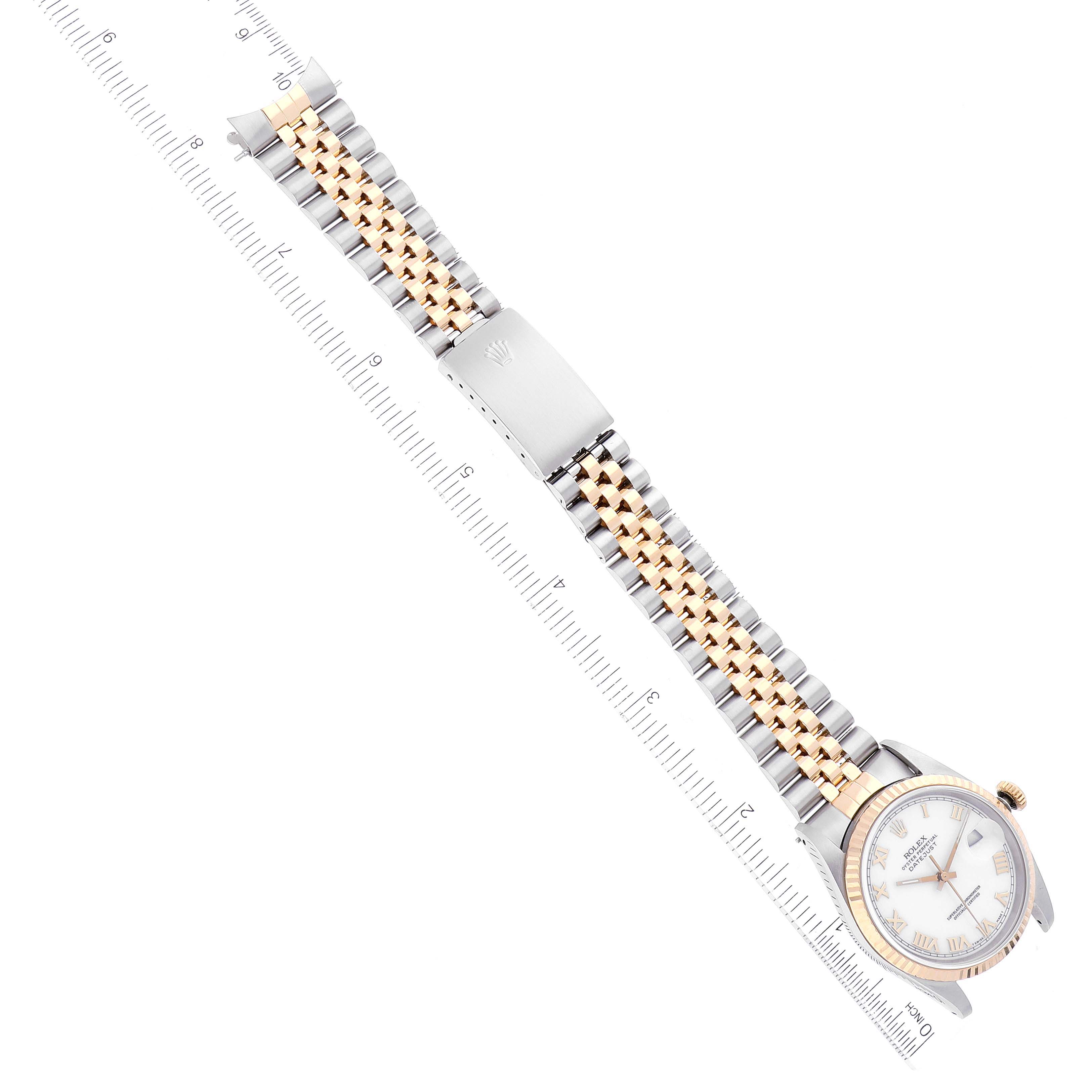 The image shows a Rolex Datejust 16233 Men's Steel and Gold (two tone) White Dial 16233 Men's Steel and Gold (two tone) White Dial watch viewed from the top, featuring the face, bezel, and two-tone bracelet alongside a ruler for scale.