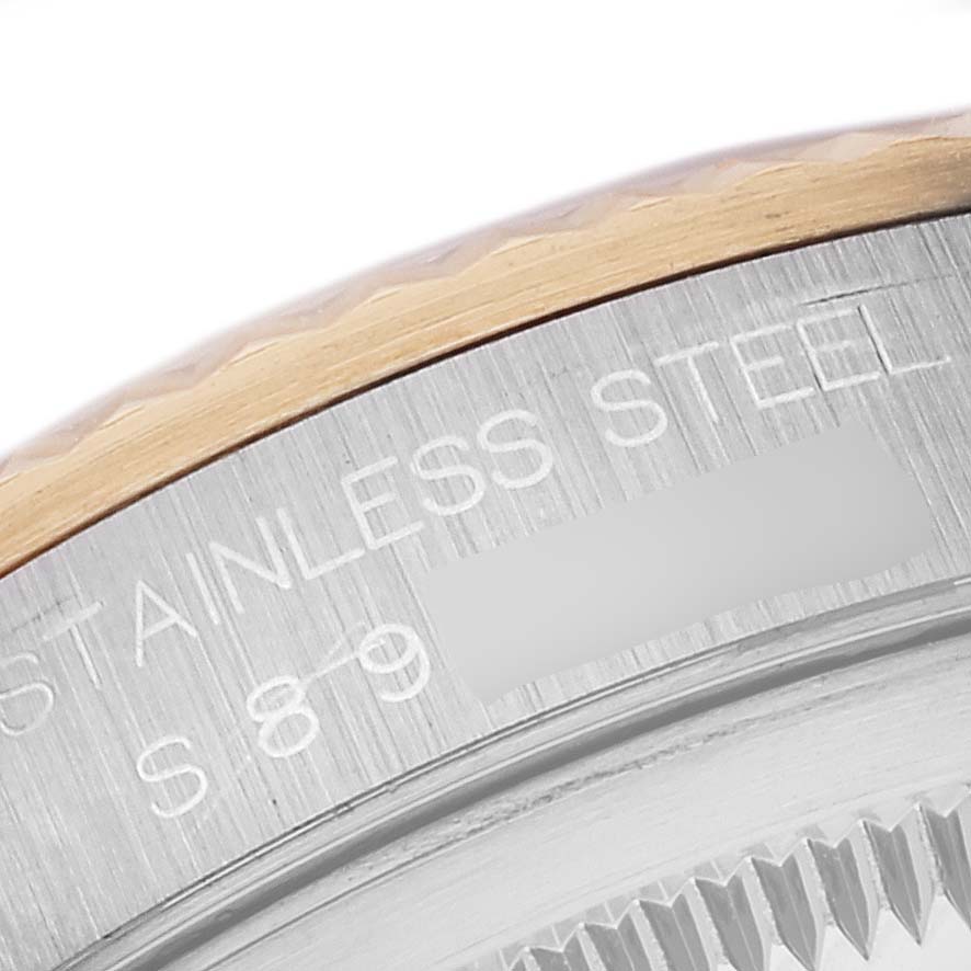 This close-up image shows a portion of the bezel and caseback of a Rolex Datejust 16233 Men's Steel and Gold (two tone) White Dial 16233 Men's Steel and Gold (two tone) White Dial, highlighting the "Stainless Steel" engraving.