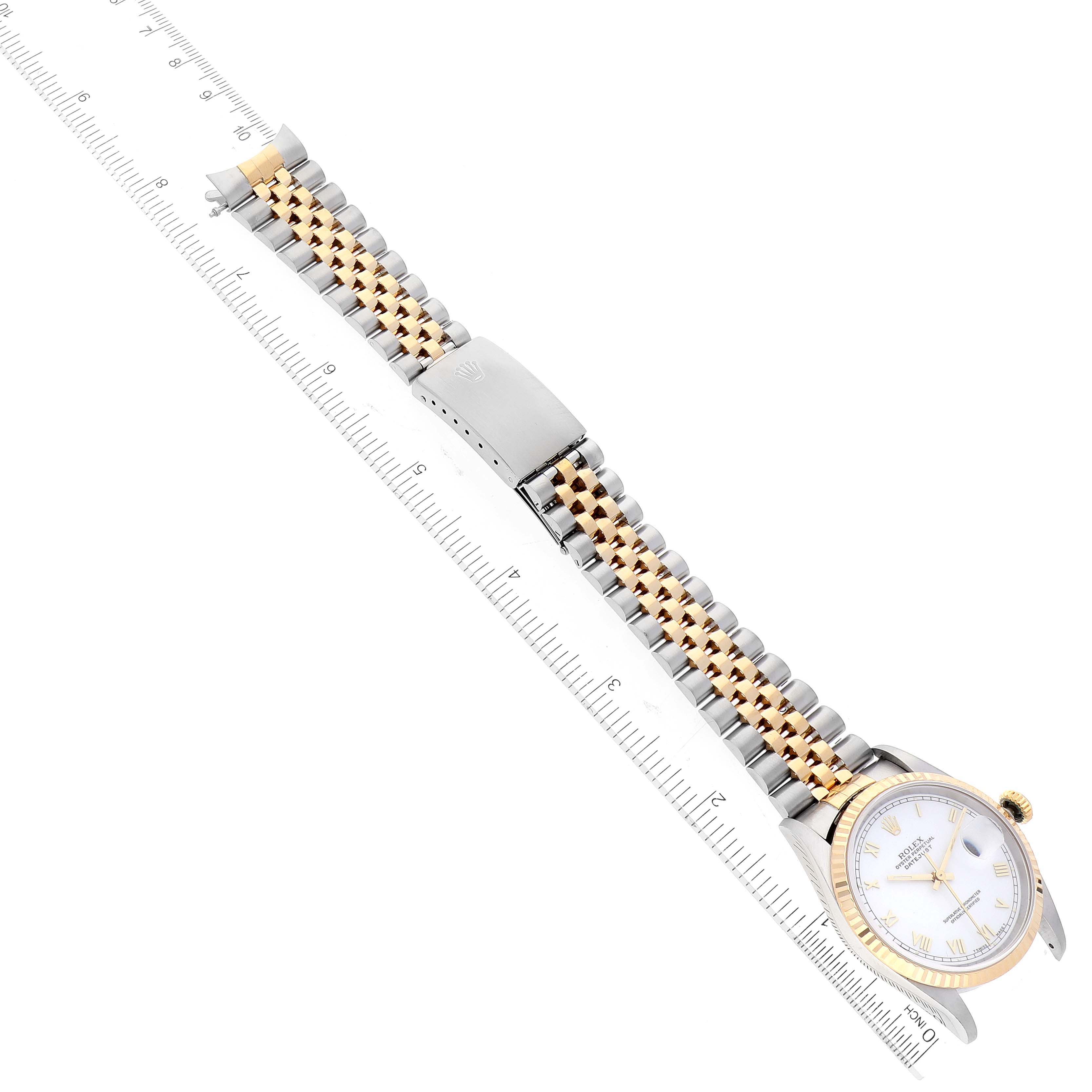 The image shows a Rolex Datejust 16233 Men's Steel and Gold (two tone) White Dial 16233 Men's Steel and Gold (two tone) White Dial watch laid flat, with a focus on the band and clasp, alongside a ruler for measurement.
