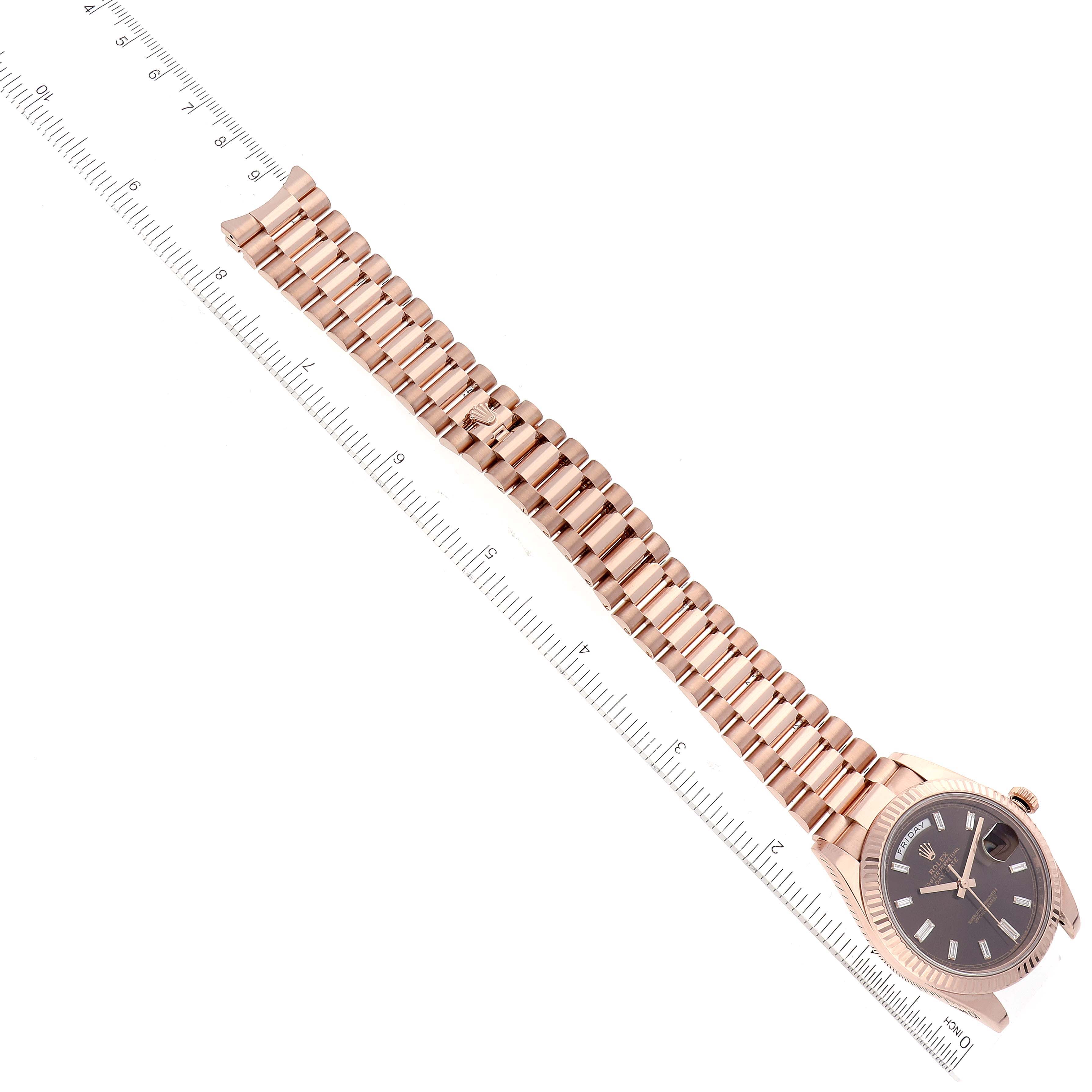 The image shows a side angle of a Rolex President 228235 Men's Rose Gold Brown Dial 228235 Men's Rose Gold Brown Dial watch with a ruler to measure the bracelet length.