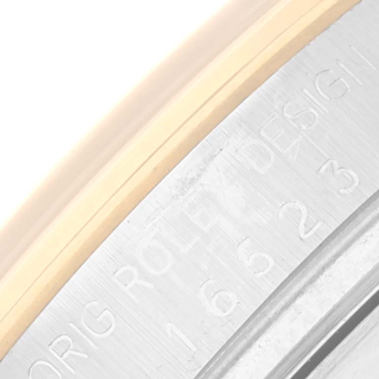 The image shows a close-up of the engraved side of the bezel of a Rolex Daytona 16523 Men's Steel and Gold (two tone) Champagne Dial 16523 Men's Steel and Gold (two tone) Champagne Dial watch with "ROLEX DESIGN" text visible.