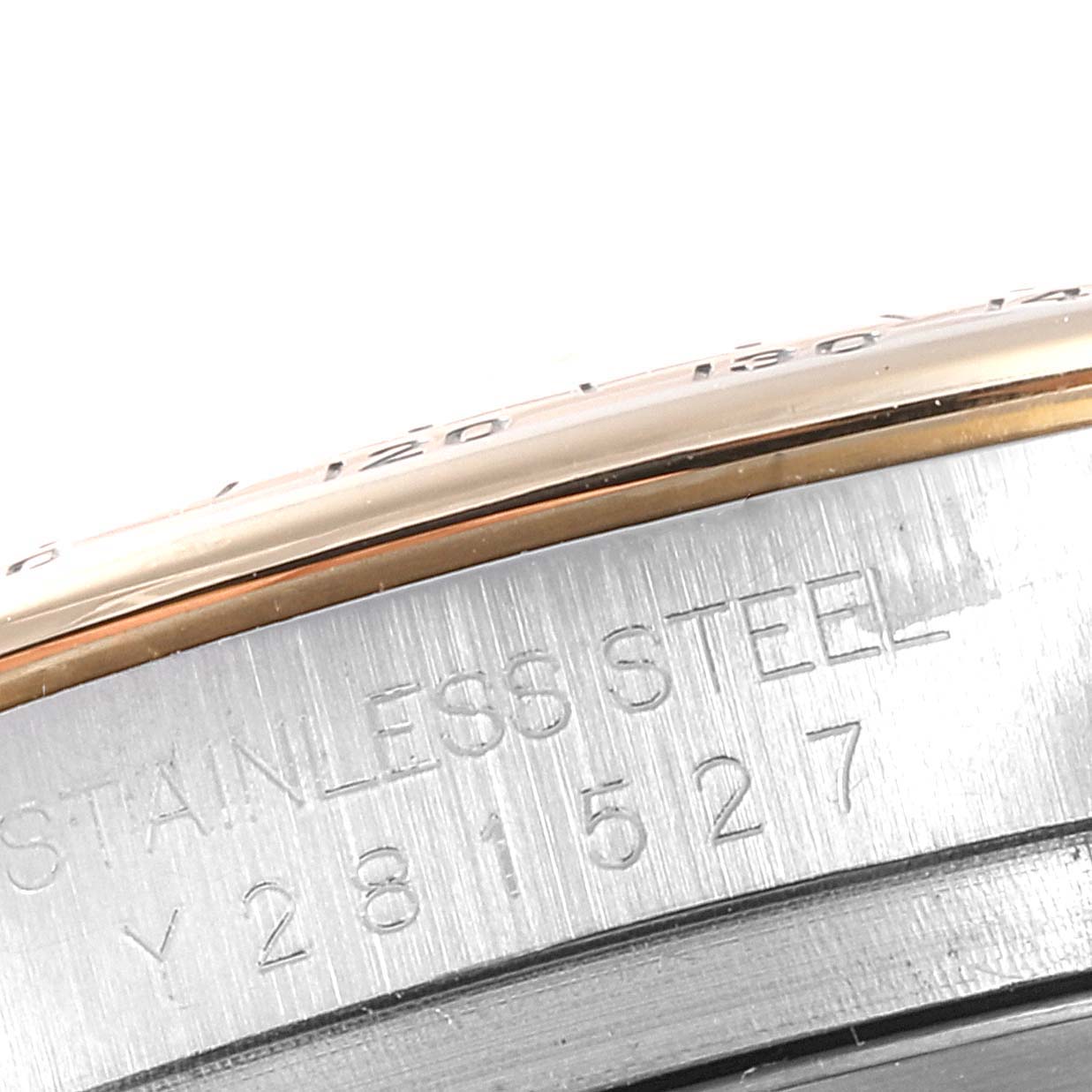 The image shows a close-up partial view of the bezel and case side of a Rolex Daytona 116523 Men
s Steel and Gold (two tone) Black Dial 116523 Men
s Steel and Gold (two tone) Black Dial watch, highlighting the serial number and "STAINLESS STEEL" engraving.