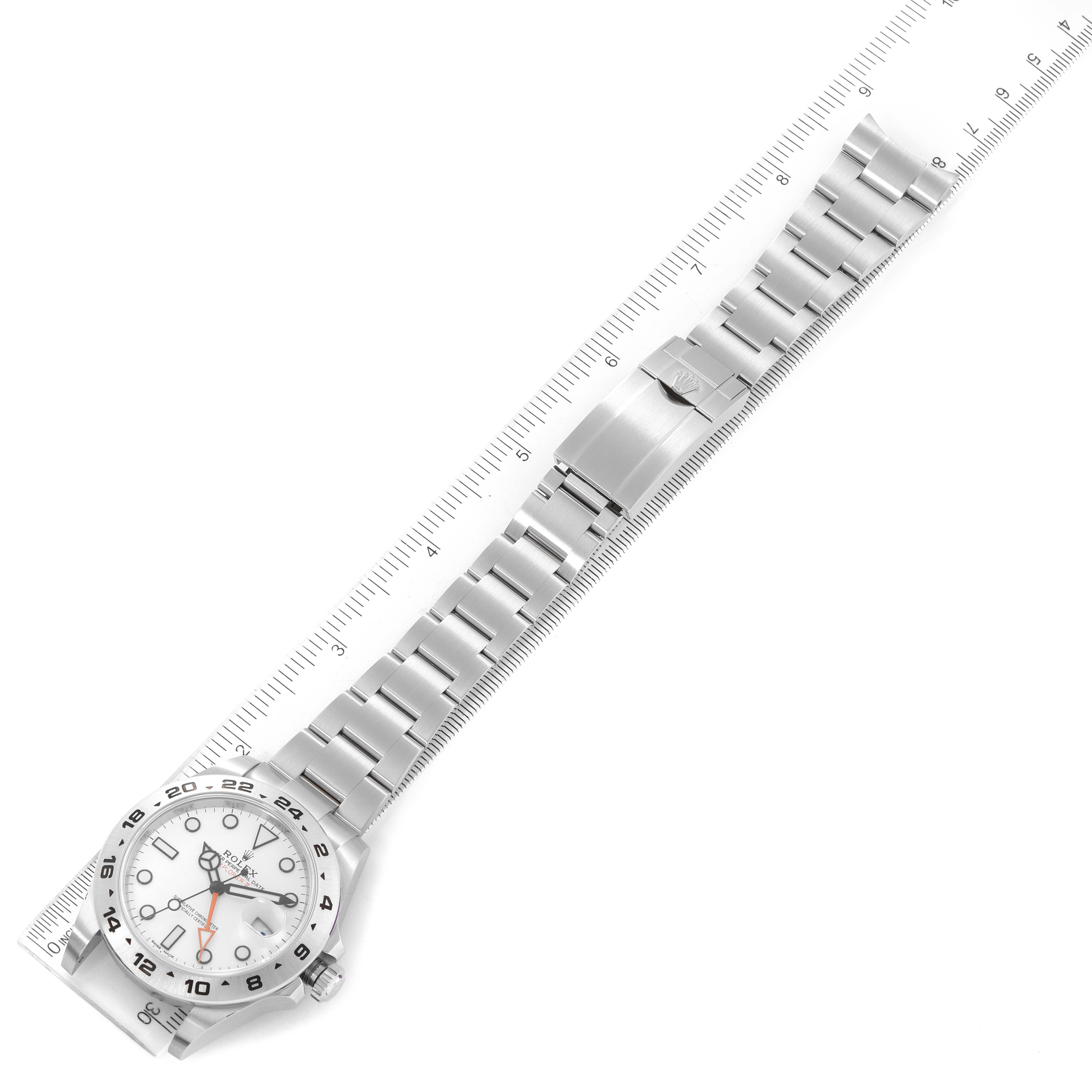 The image shows a Rolex Explorer 216570 Men
s Stainless Steel White Dial 216570 Men
s Stainless Steel White Dial watch laid flat with its bracelet and clasp extended next to a ruler for measurement.