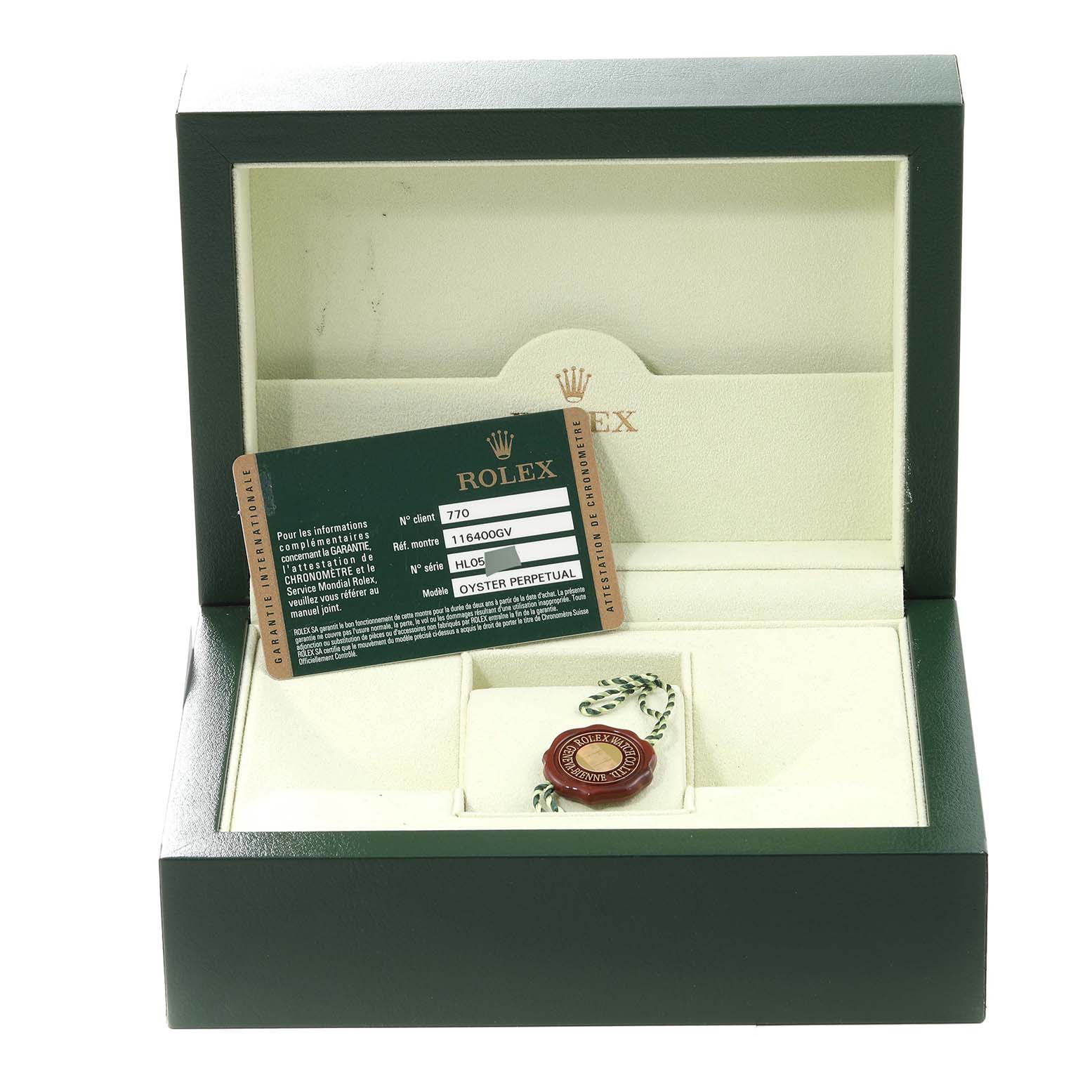 The image shows the accessories of a Rolex Milgauss 116400 Men's Stainless Steel Black Dial 116400 Men's Stainless Steel Black Dial, including a guarantee card and a seal inside a green Rolex box.