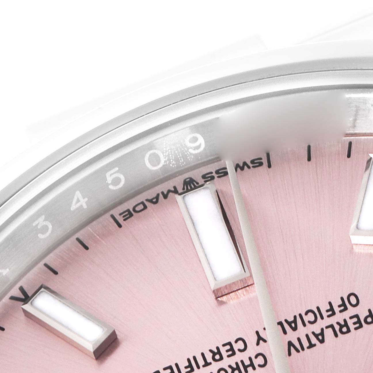 This close-up image of a Rolex Oyster Perpetual 124200 Men
s Stainless Steel Pink Dial 124200 Men
s Stainless Steel Pink Dial watch shows part of the dial and bezel with text and indices.