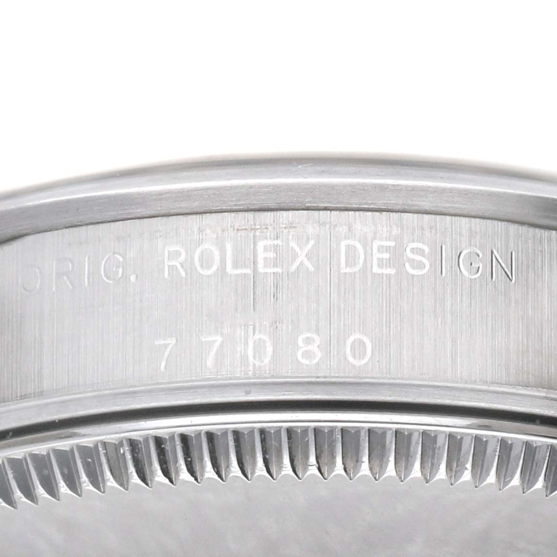 The image shows a close-up of the engraved bezel of a Rolex Oyster Perpetual 77080 Women's Stainless Steel Black Dial watch, highlighting the "ROLEX DESIGN" inscription.
