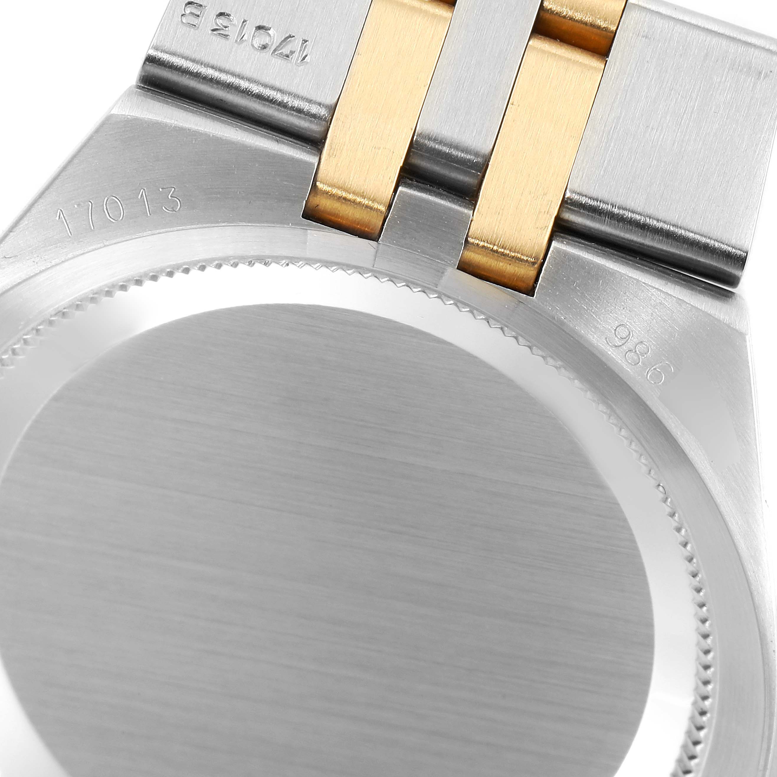 Close-up of the back case and part of the clasp of a Rolex Oysterquartz 17013 Men's Steel and Gold (two tone) Champagne Dial 17013 Men's Steel and Gold (two tone) Champagne Dial model watch, showing the serial number.