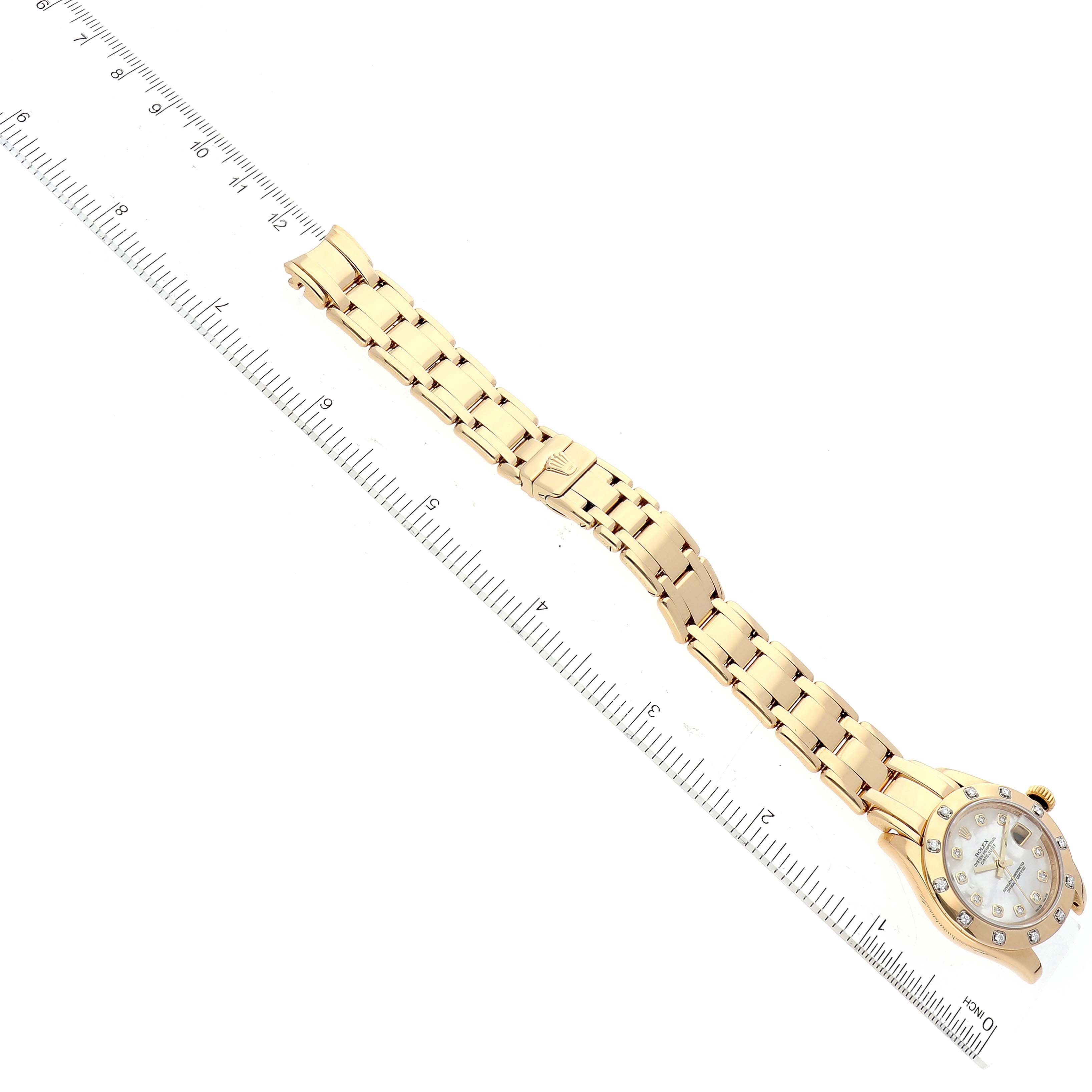 The Rolex Pearlmaster 80318 Women's Yellow Gold Mother of Pearl Dial 80318 Women's Yellow Gold Mother of Pearl Dial watch is shown flat, with the bracelet and case visible, alongside a ruler for scale.