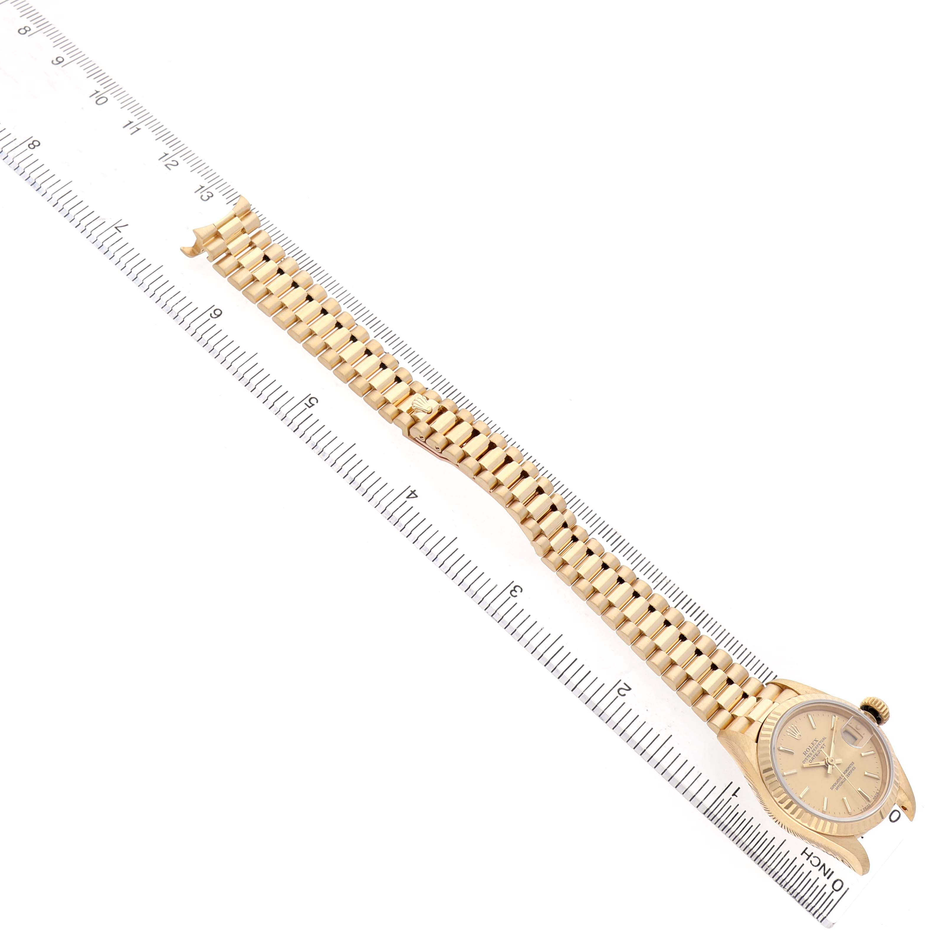The Rolex President 69178 Women's Yellow Gold Champagne Dial watch is photographed from a top view, showing the face, bezel, and full bracelet aligned with a ruler.