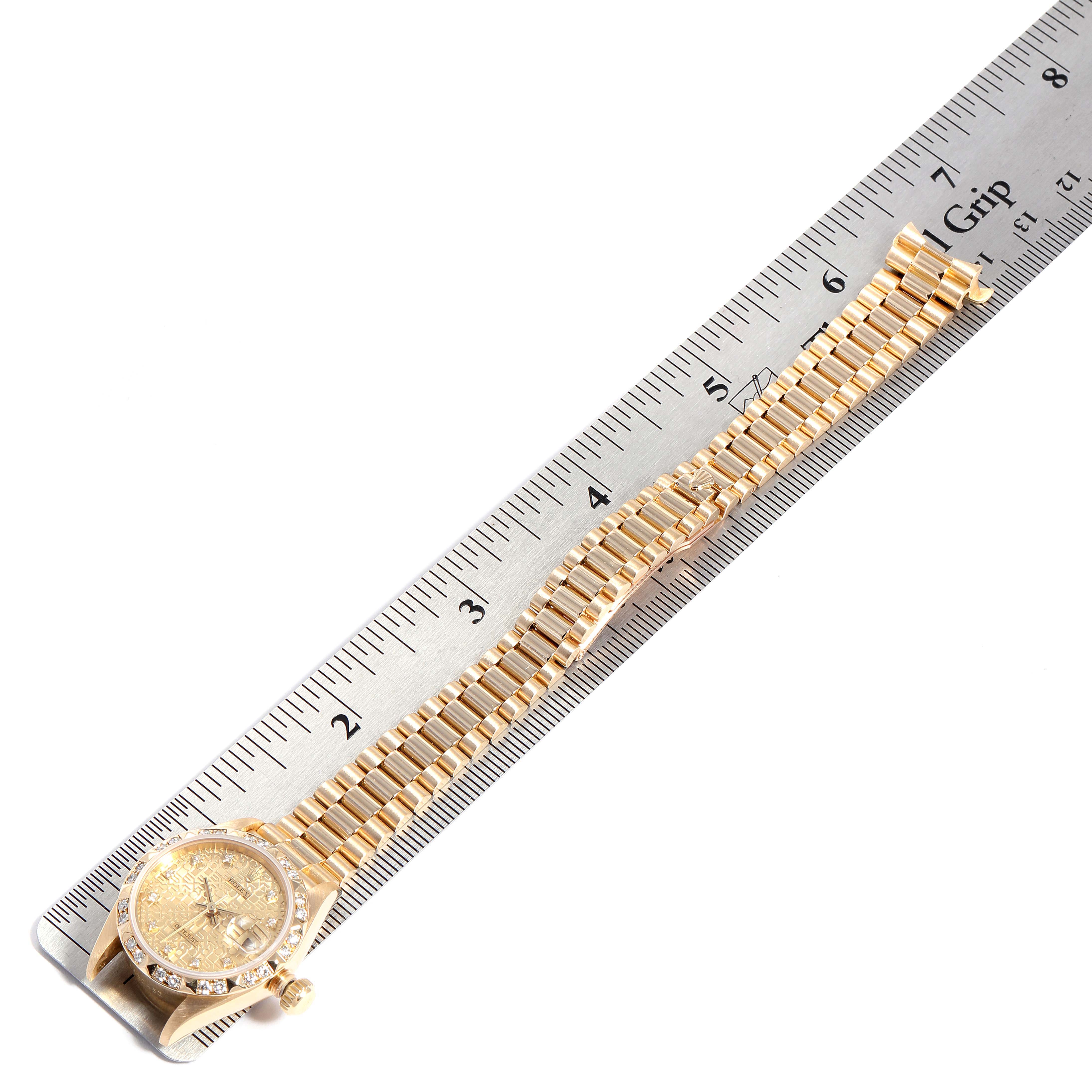 The image shows a Rolex President 69258 Women
s Yellow Gold Champagne Dial 69258 Women
s Yellow Gold Champagne Dial watch laid flat next to a metal ruler, capturing the full watch and band at an angle.