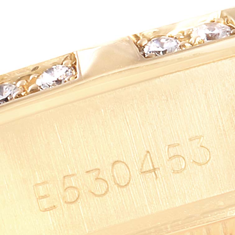 The image shows a close-up of the Rolex President 69258 Women
s Yellow Gold Champagne Dial 69258 Women
s Yellow Gold Champagne Dial watch
s case, featuring serial numbers and diamond accents.