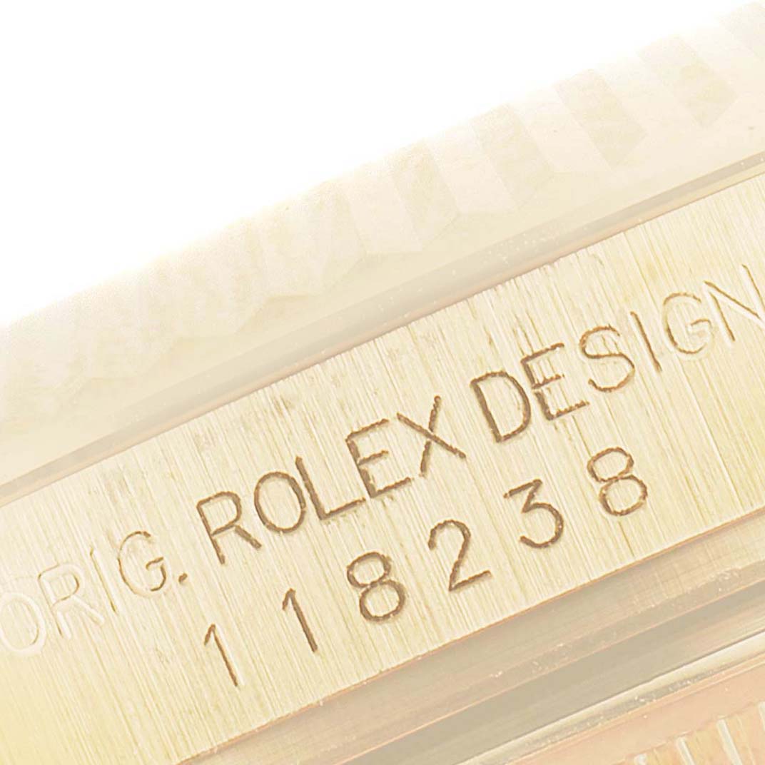 The image shows a close-up of the engraved serial number and "ROLEX DESIGN" text on the bezel of a Rolex President 118238 Men's Yellow Gold Champagne Dial 118238 Men's Yellow Gold Champagne Dial model.