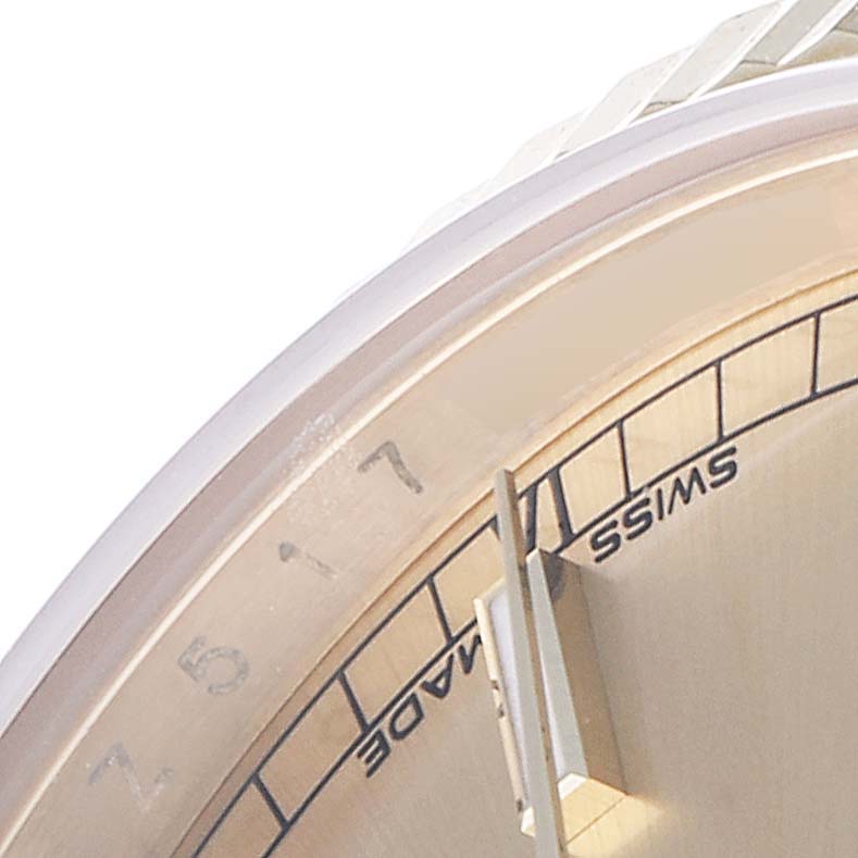This close-up image of the Rolex President 118238 Men's Yellow Gold Champagne Dial 118238 Men's Yellow Gold Champagne Dial model shows a portion of the dial and bezel with minute markers and part of an hour marker.