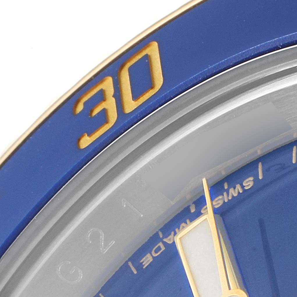 This image shows a close-up of the bezel and a portion of the dial of a Rolex Submariner 116613 Men
s Steel and Gold (two tone) Blue Dial 116613 Men
s Steel and Gold (two tone) Blue Dial watch.