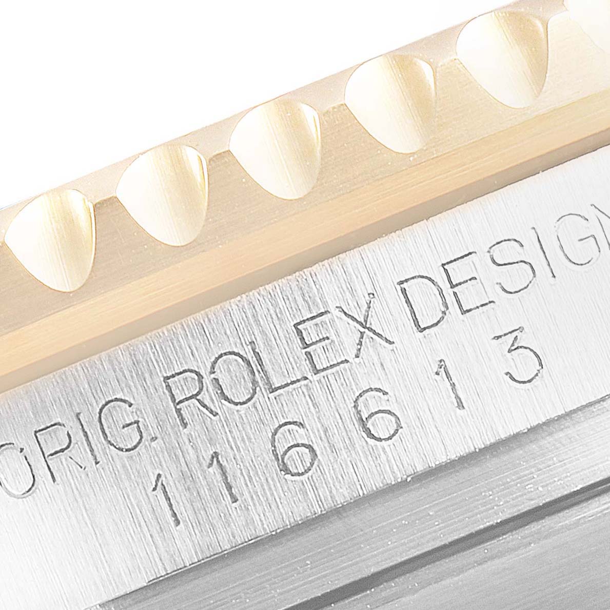 This close-up image shows the edge of the bezel and the engraved model number on the case of a Rolex Submariner 116613 Men
s Steel and Gold (two tone) Blue Dial 116613 Men
s Steel and Gold (two tone) Blue Dial.