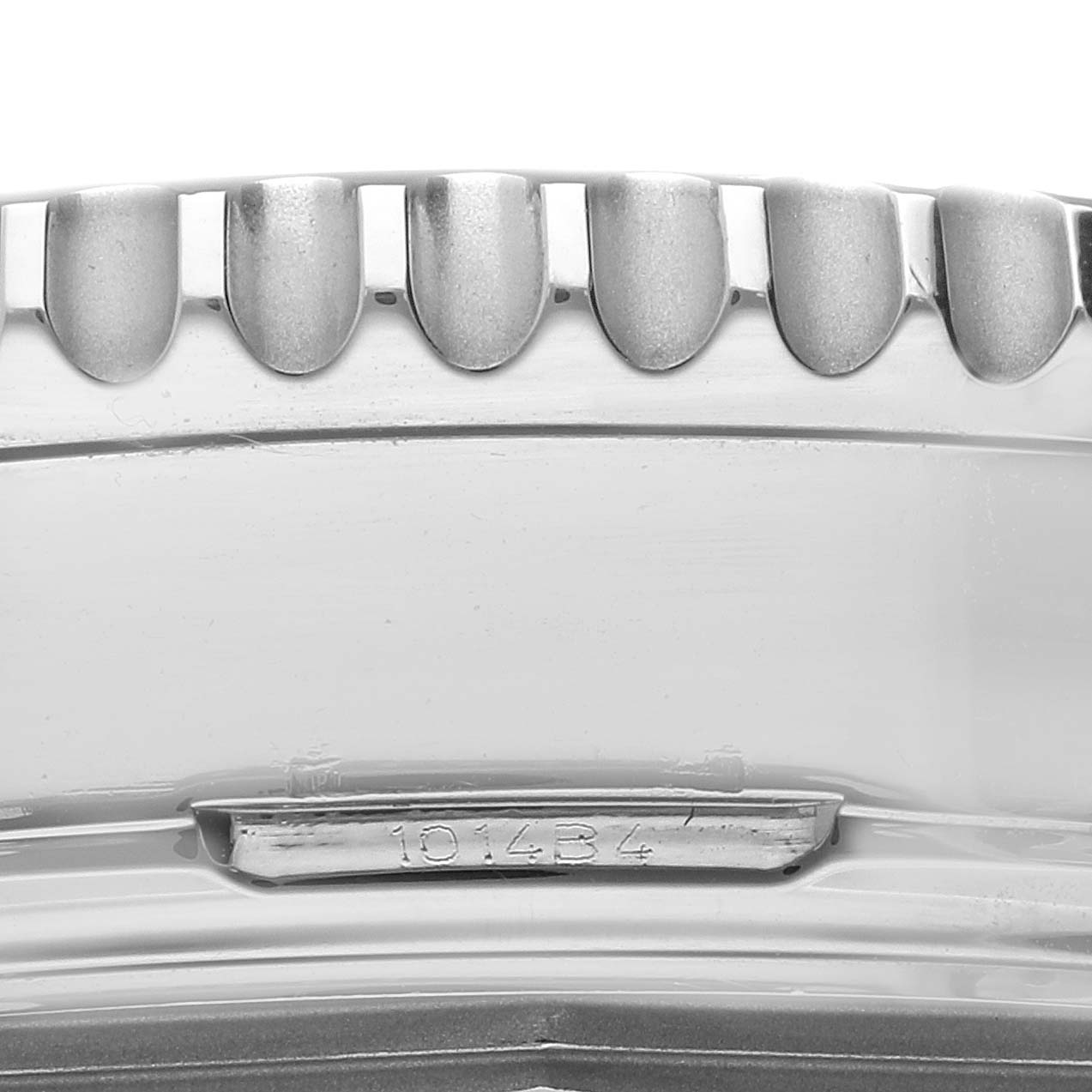 The image shows a close-up of the knurled bezel edge of a Breitling Navitimer AB0441 Men
s Stainless Steel Black Dial AB0441 Men
s Stainless Steel Black Dial watch, along with part of the case and a serial number.