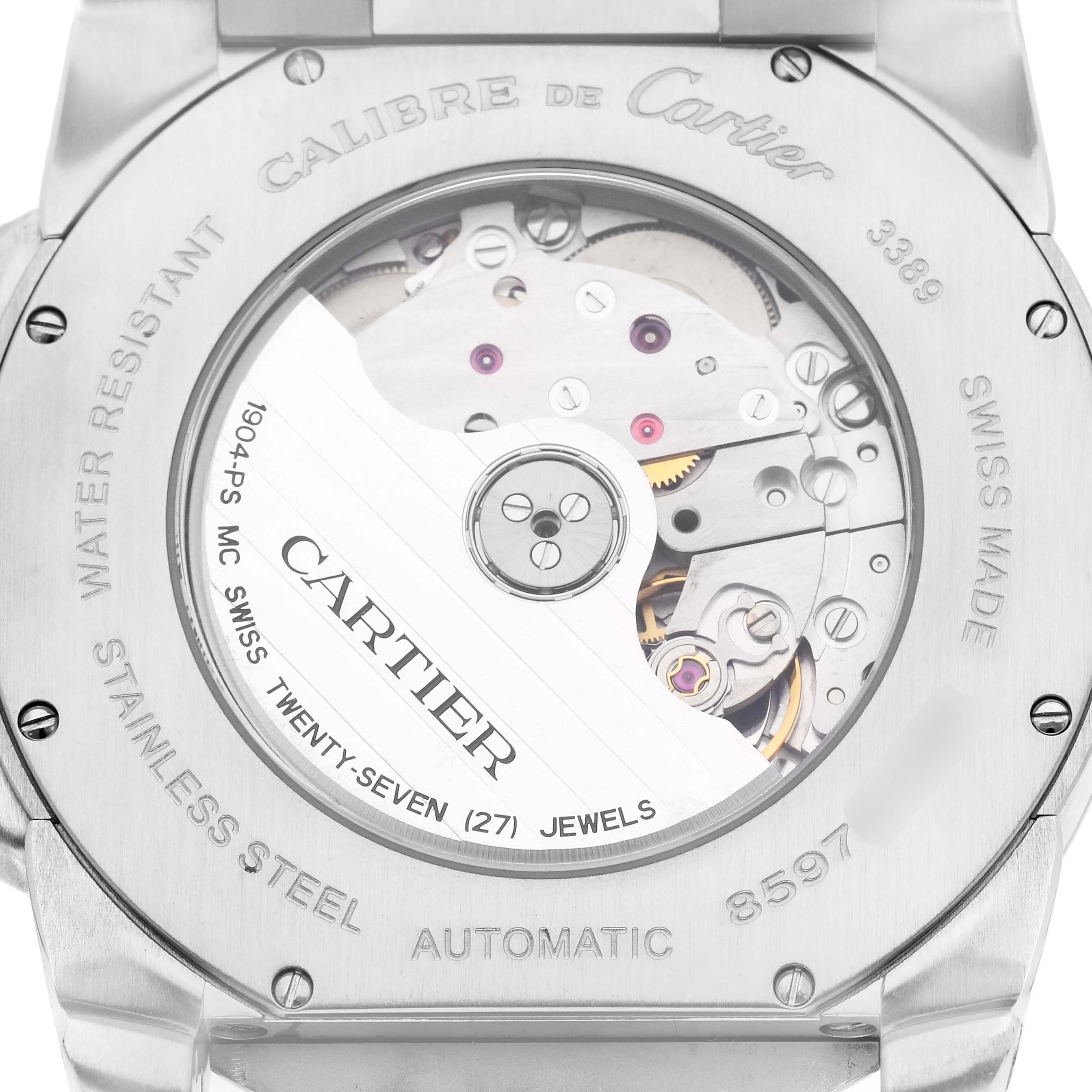 The image shows the back case of the Calibre de Cartier watch, revealing its automatic movement and internal components.