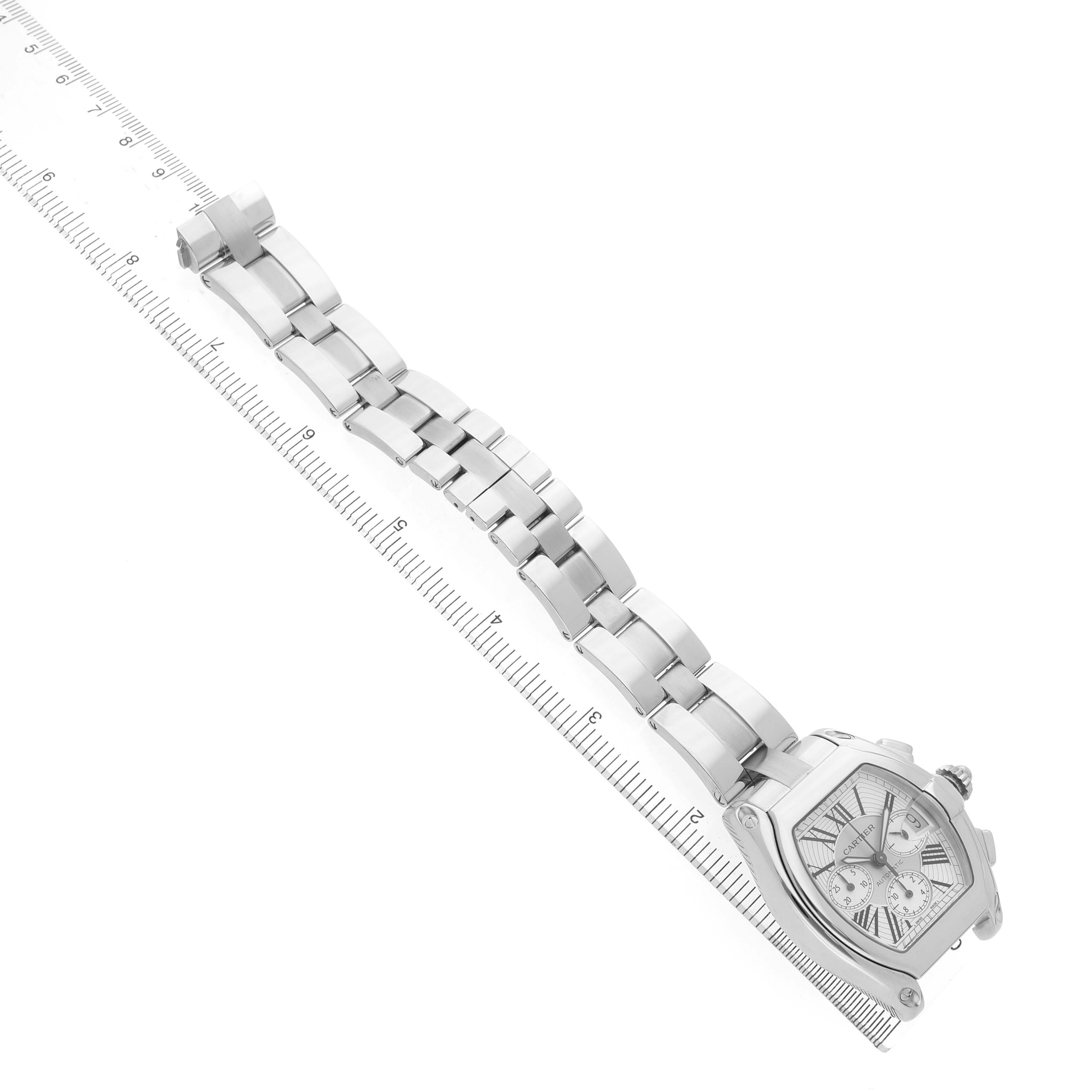 The Cartier Roadster W62019X6 Men's Stainless Steel Silver Dial watch is shown from the top, displaying the face, bracelet, and crown alongside a ruler for scale.