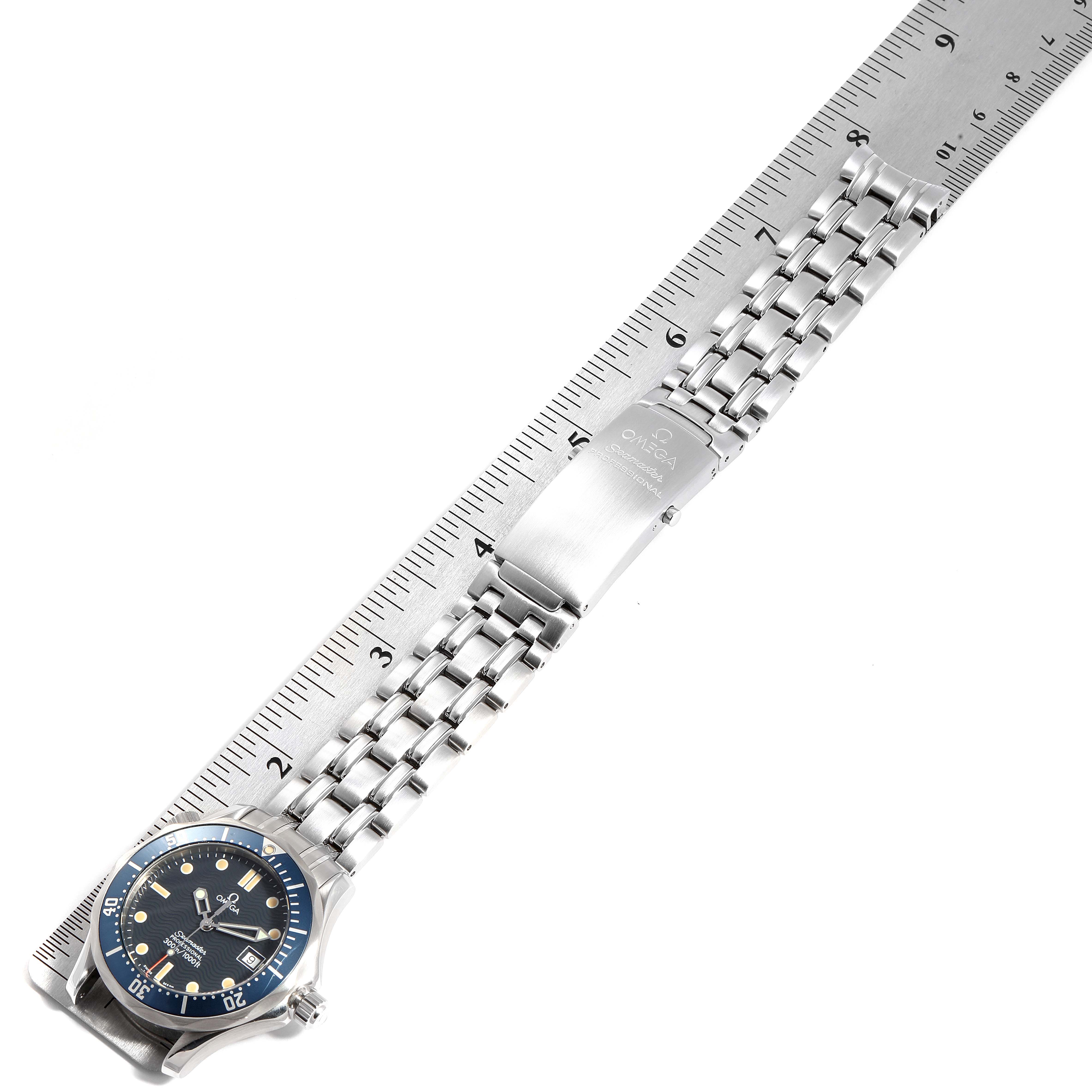 The image shows an Omega Seamaster 2561.80.00 Men
s Stainless Steel Blue Dial 2561.80.00 Men
s Stainless Steel Blue Dial watch laid flat with its stainless steel bracelet and clasp in full view alongside a ruler.