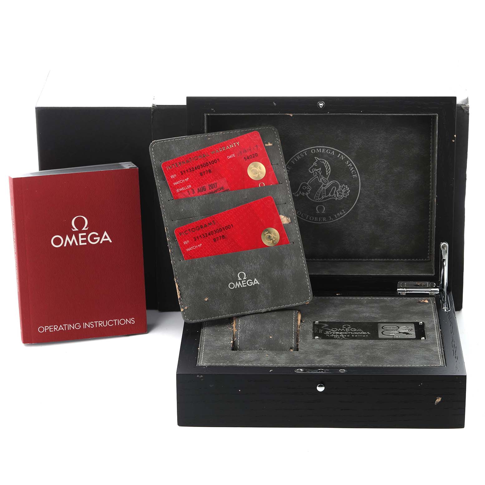 The image shows an Omega Speedmaster 311.32.40.30.01.001 Men
s Stainless Steel Black Dial 311.32.40.30.01.001 Men
s Stainless Steel Black Dial box with warranty cards and a red instruction booklet visible.