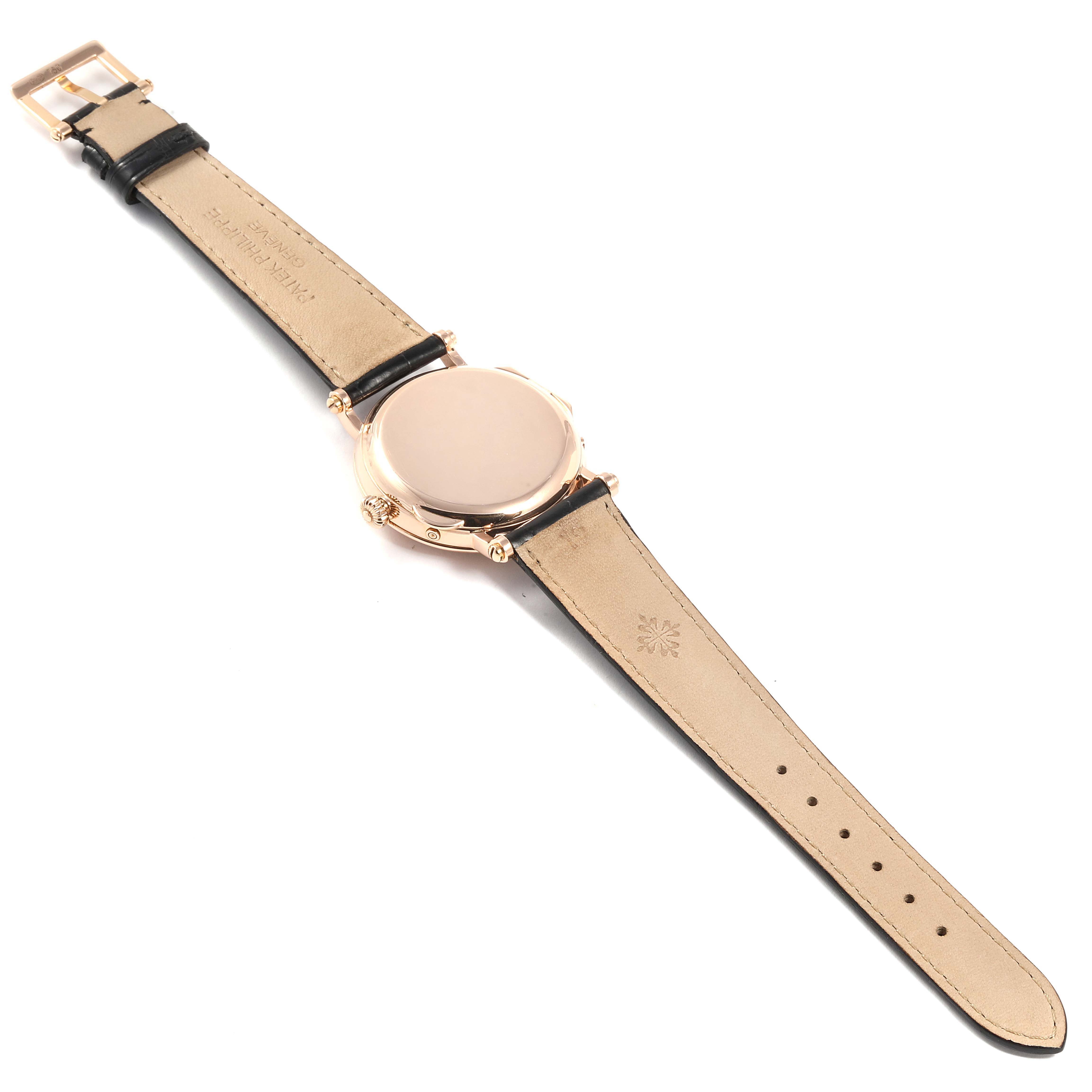 The image shows the back view of a Patek Philippe Complications 5054 Men's Rose Gold White Dial 5054 Men's Rose Gold White Dial watch with black leather straps and a gold-tone case.