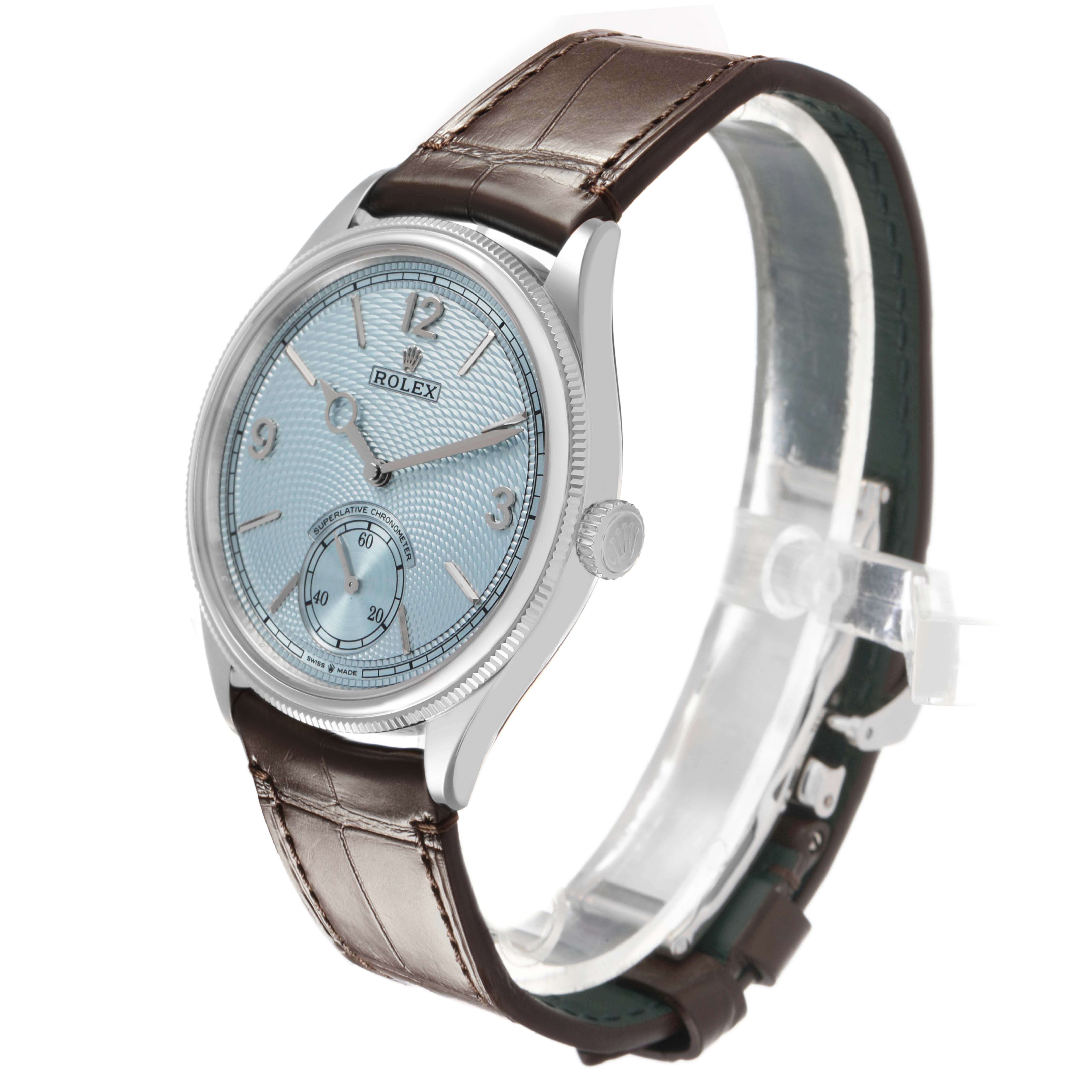 The Rolex 1908 52506 Men's Platinum Blue Dial model watch is shown at a three-quarter angle, displaying its face, bezel, crown, and brown leather strap.