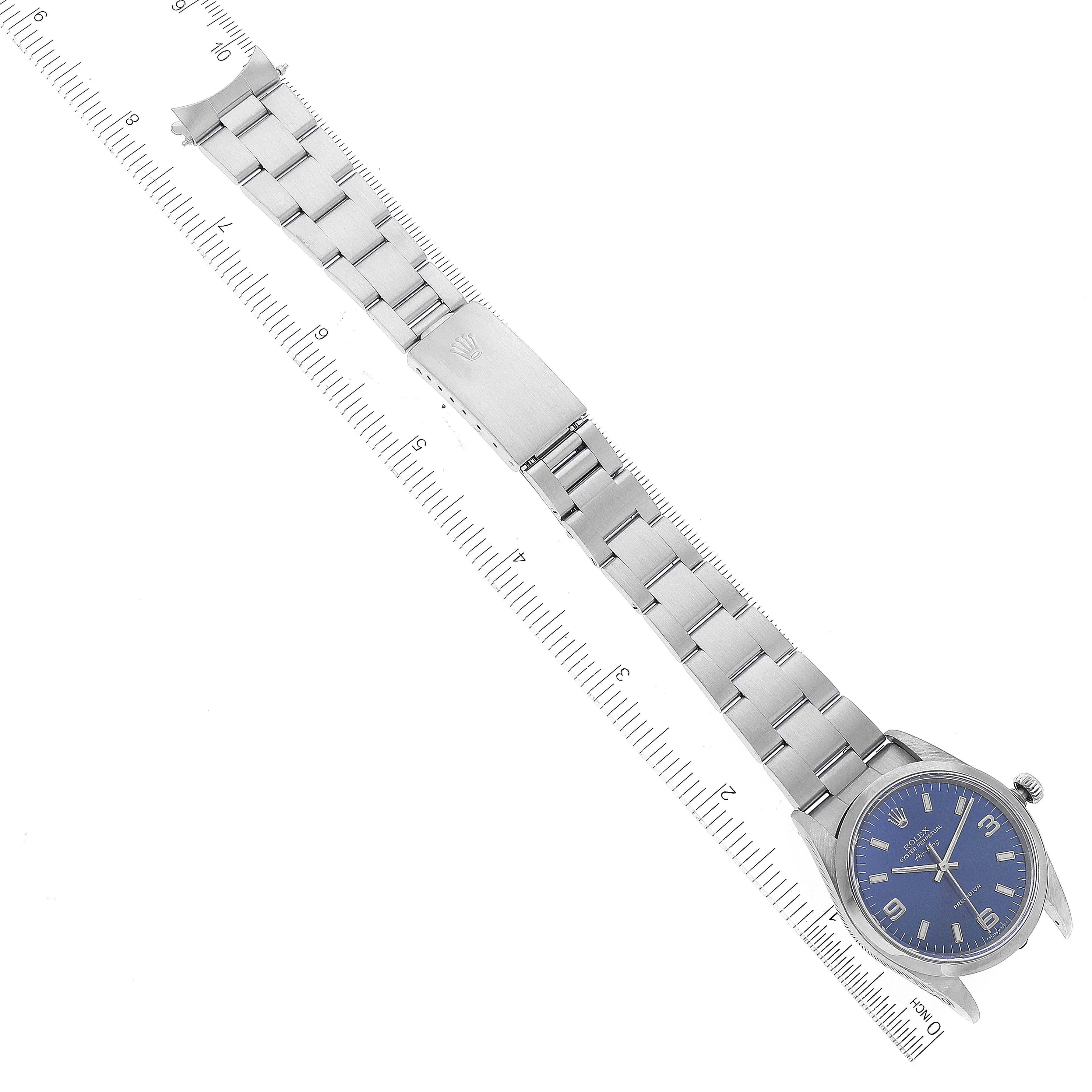 The Rolex Air-King 14000 Men's Stainless Steel Blue Dial 14000 Men's Stainless Steel Blue Dial watch is shown at a top-down angle with a blue dial and a stainless steel bracelet beside a ruler.