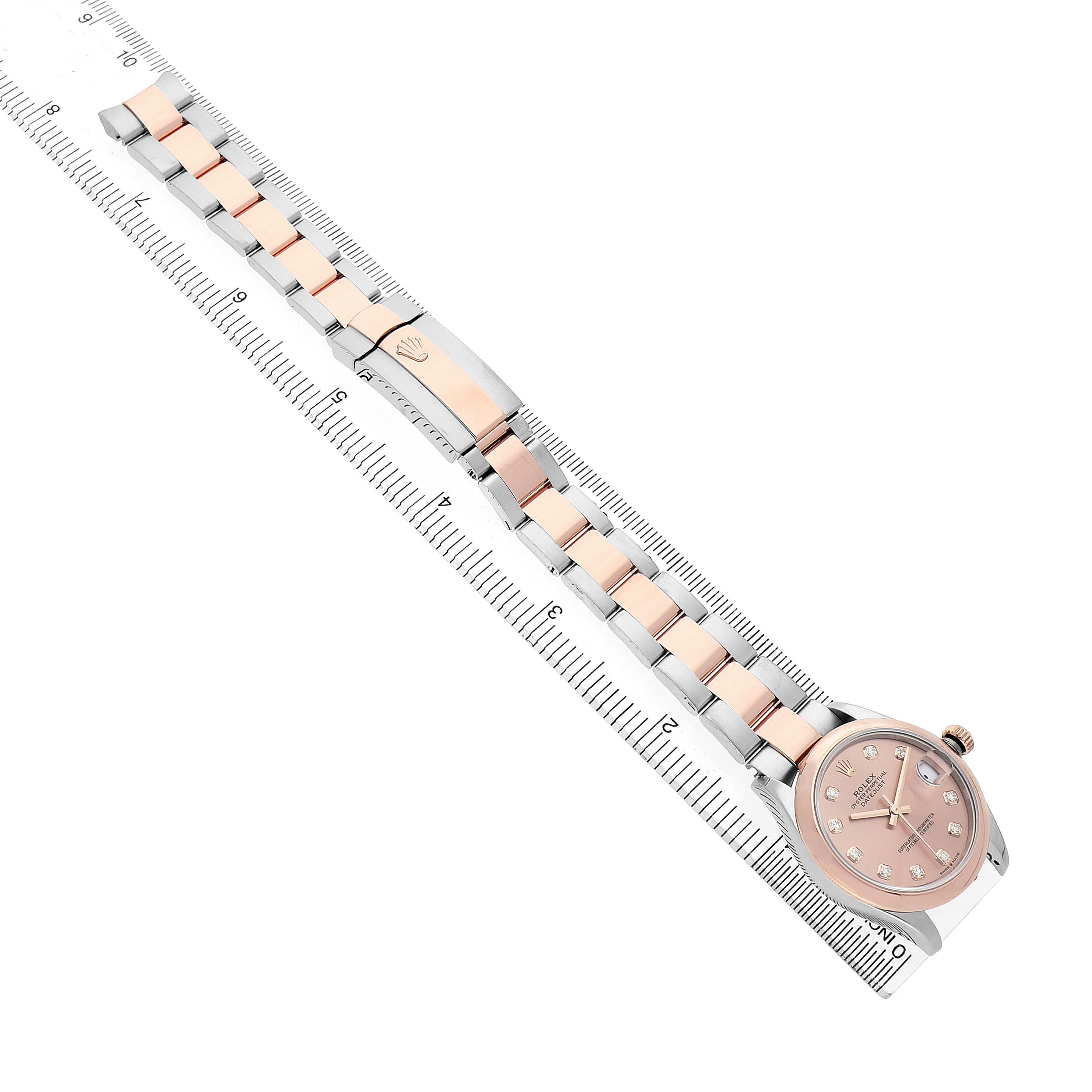 The Rolex Datejust 278241 Women's Stainless Steel Pink Dial watch is shown at an angle with the full bracelet, clasp, and face visible alongside a ruler.
