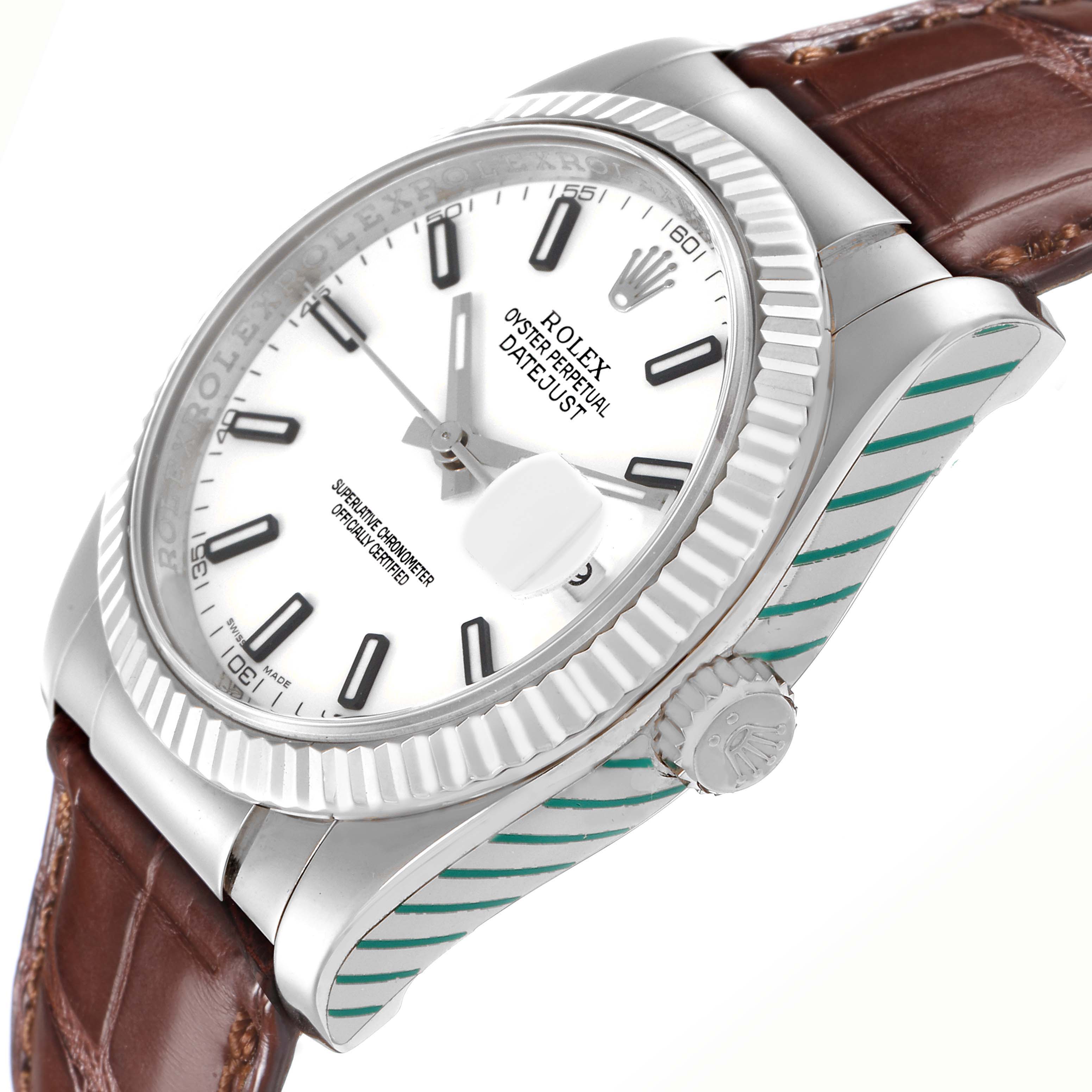 The Rolex Datejust 116139 Men's White Gold White Dial 116139 Men's White Gold White Dial watch is shown at an angle highlighting the dial, crown, bezel, and part of the leather strap.