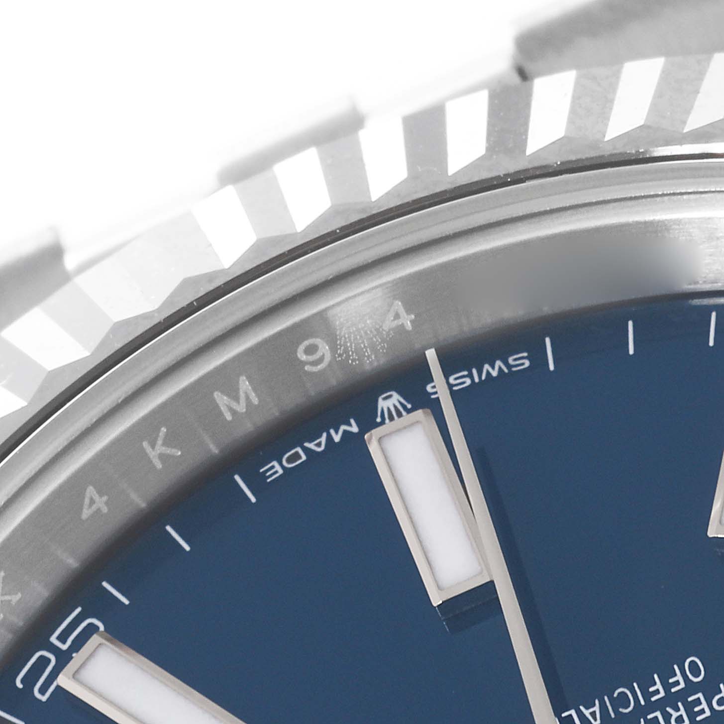 This close-up image of a Rolex Datejust 41 126334 Men's Stainless Steel Blue Dial 126334 Men's Stainless Steel Blue Dial watch shows its fluted bezel and part of its blue dial with Swiss Made marking.