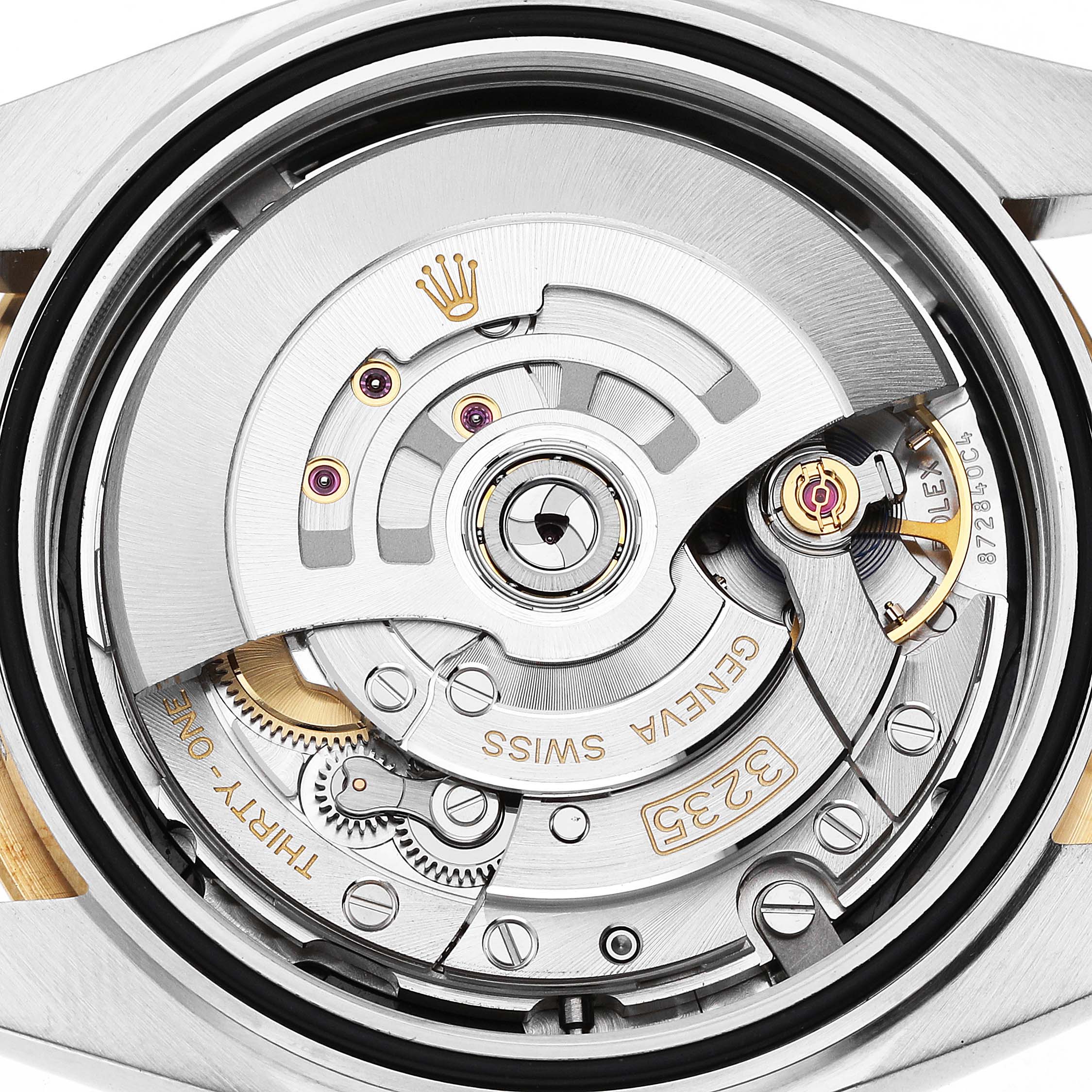 The image shows a close-up view of the movement of a Rolex Datejust 126333 Men's Steel and Gold (two tone) Black Dial, highlighting its intricate mechanical components.
