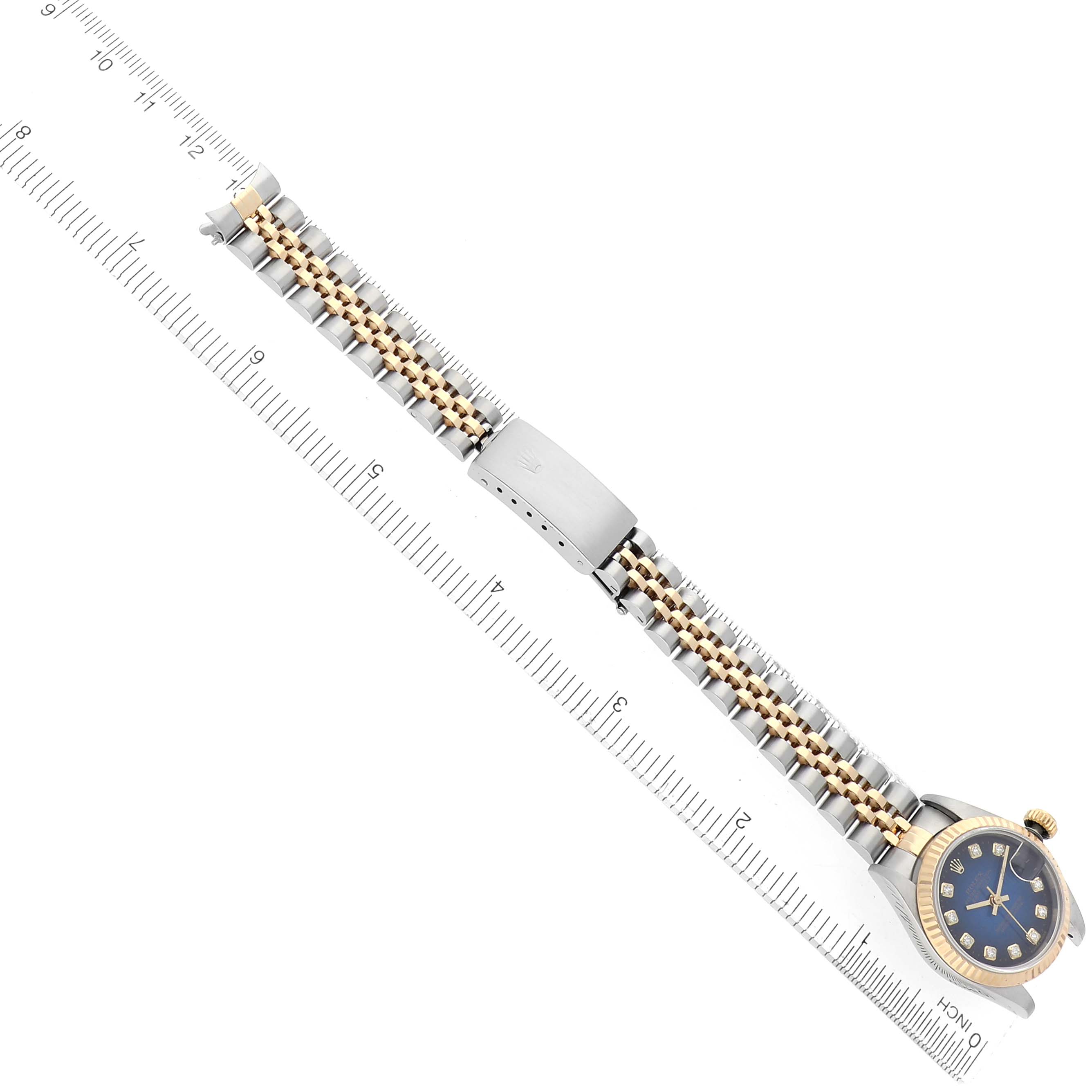 The Rolex Datejust 69173 Women
s Steel and Gold (two tone) Blue Dial 69173 Women
s Steel and Gold (two tone) Blue Dial watch is shown at a top view angle, featuring the bracelet and clasp aligned with a ruler for scale.