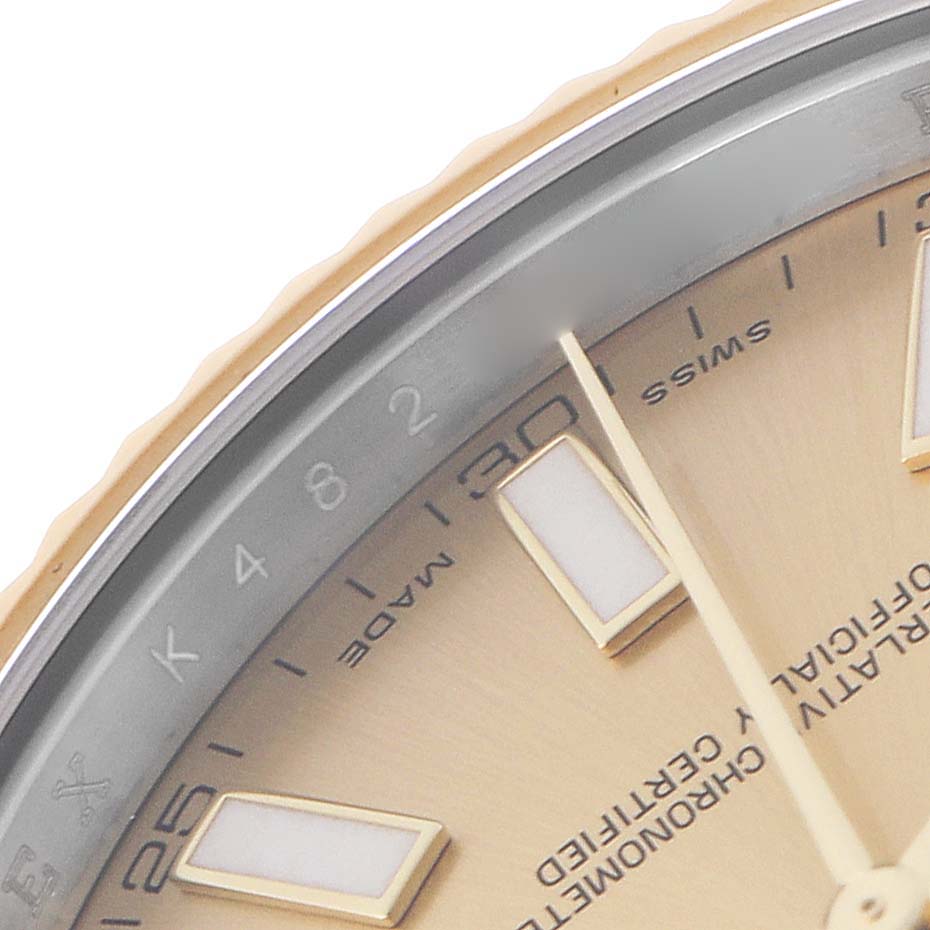 This close-up of the Rolex Datejust 116333 Men
s Steel and Gold (two tone) Champagne Dial 116333 Men
s Steel and Gold (two tone) Champagne Dial shows part of the dial, hour markers, hands, and the inner bezel with numerals and text.