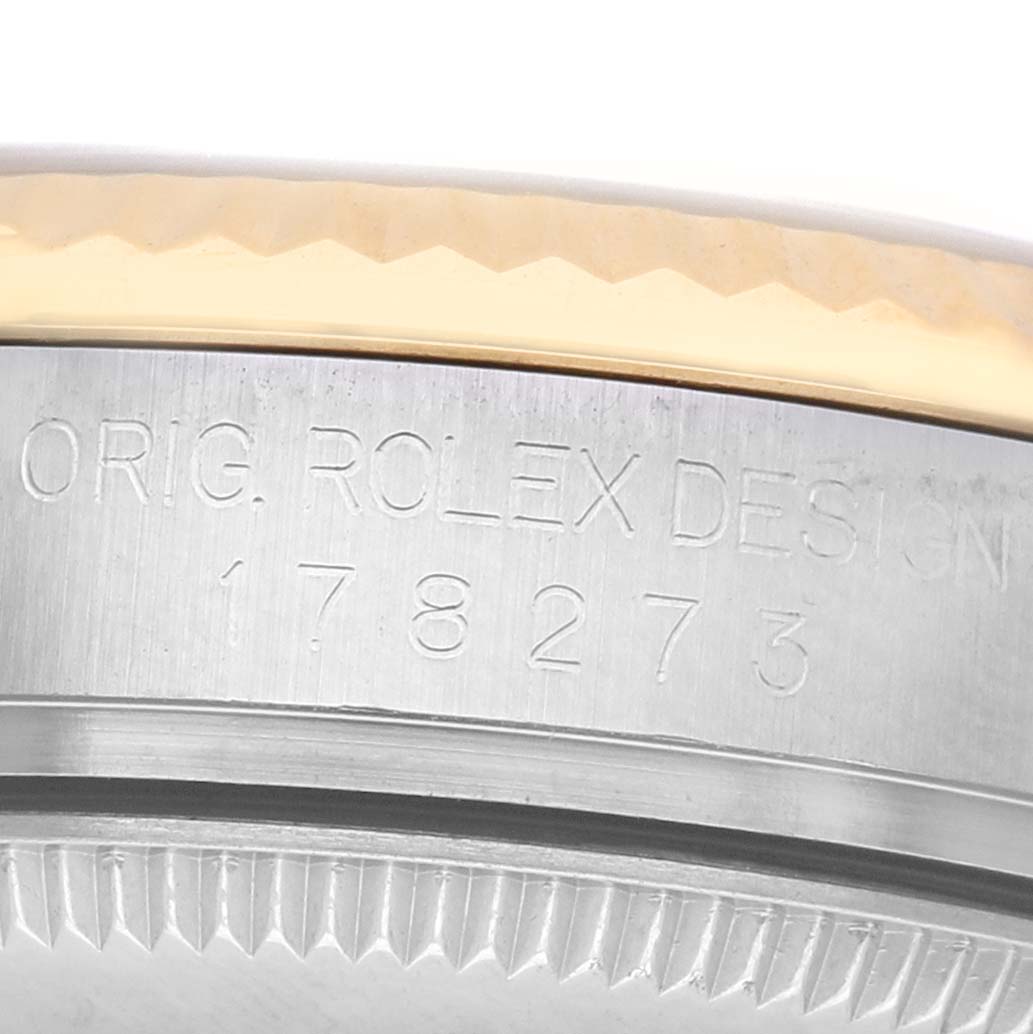The image shows the side view of a Rolex Datejust 178273 Women's Steel and Gold (two tone) Champagne Dial, highlighting the engraved model number and part of the bezel.