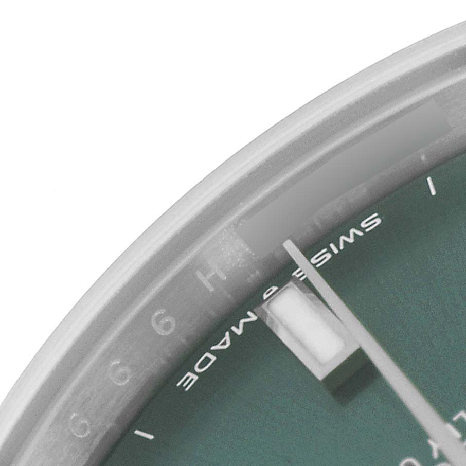 The image shows a close-up angle of the dial and bezel of a Mid-Size Rolex watch, focusing on the "Swiss Made" text and part of the minute hand.