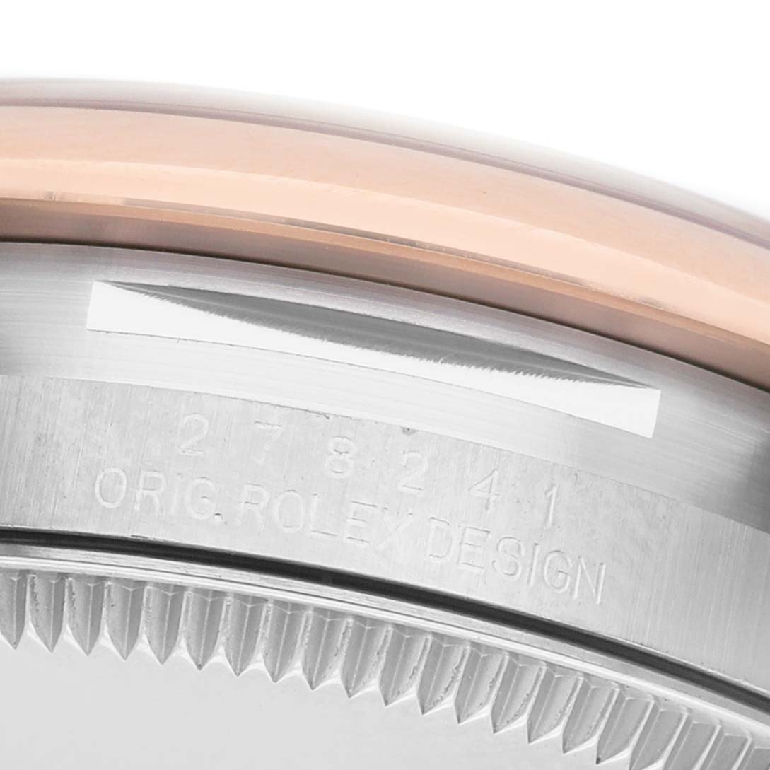 The image shows the side of the Rolex Datejust 278241 Women's Steel and Gold (two tone) White Dial watch, focusing on the engraved case and bezel.