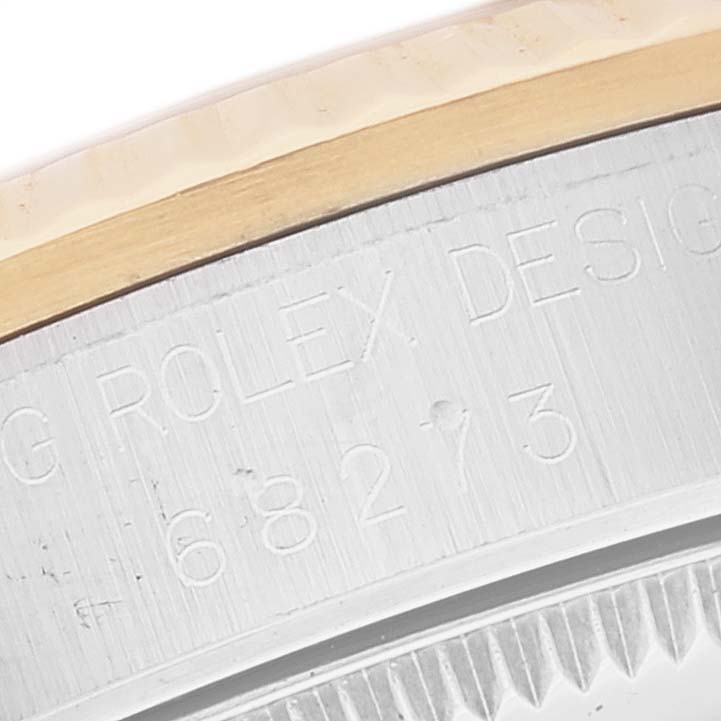The image shows a partial engraving on the side of a Rolex Mid-Size 68273 Women's Steel and Gold (two tone) Champagne Dial 68273 Women's Steel and Gold (two tone) Champagne Dial model watch, including part of the bezel and case.