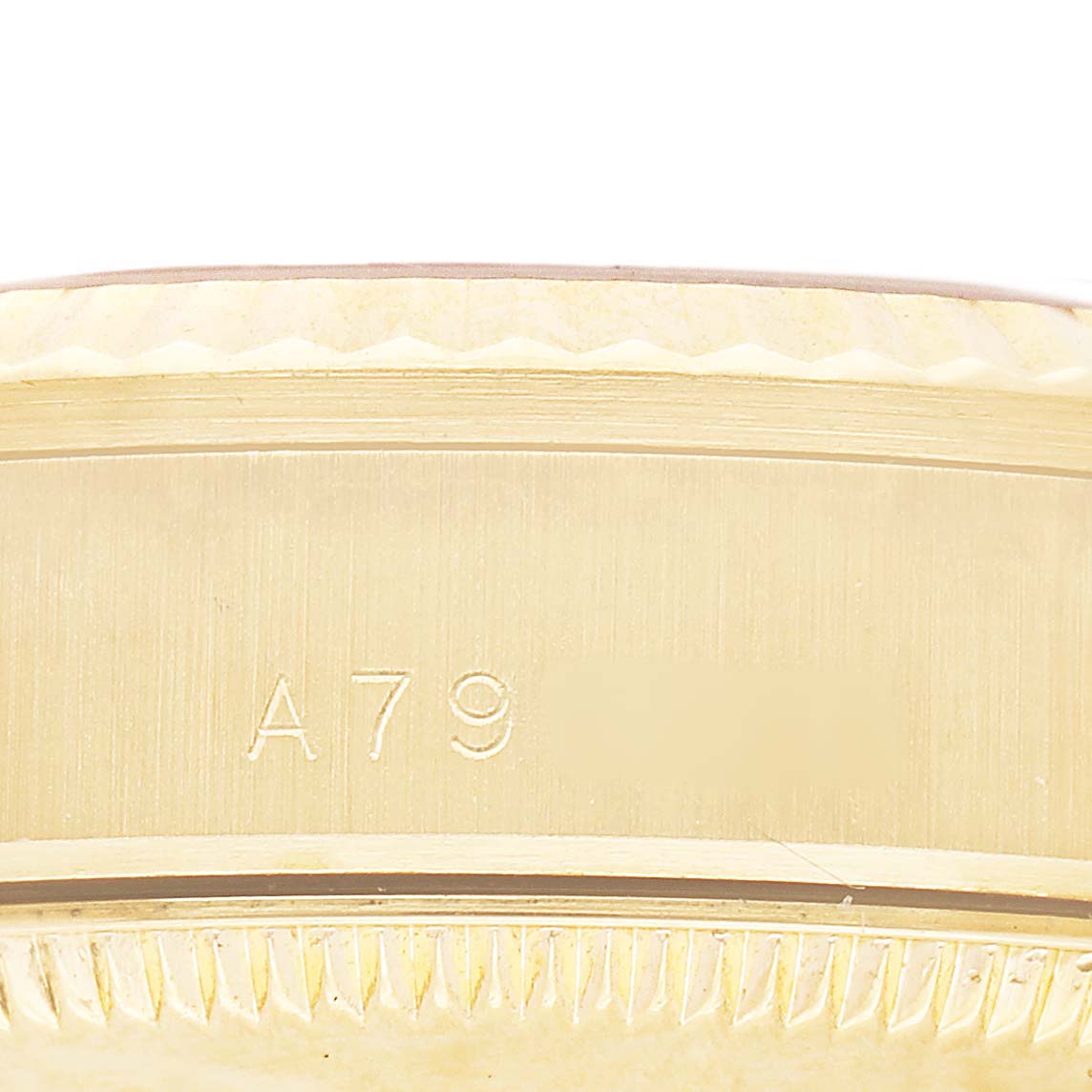 This image shows a close-up of the side of a Rolex Datejust 78278 Women's Yellow Gold Champagne Dial, highlighting the engraved serial number and part of the fluted bezel.