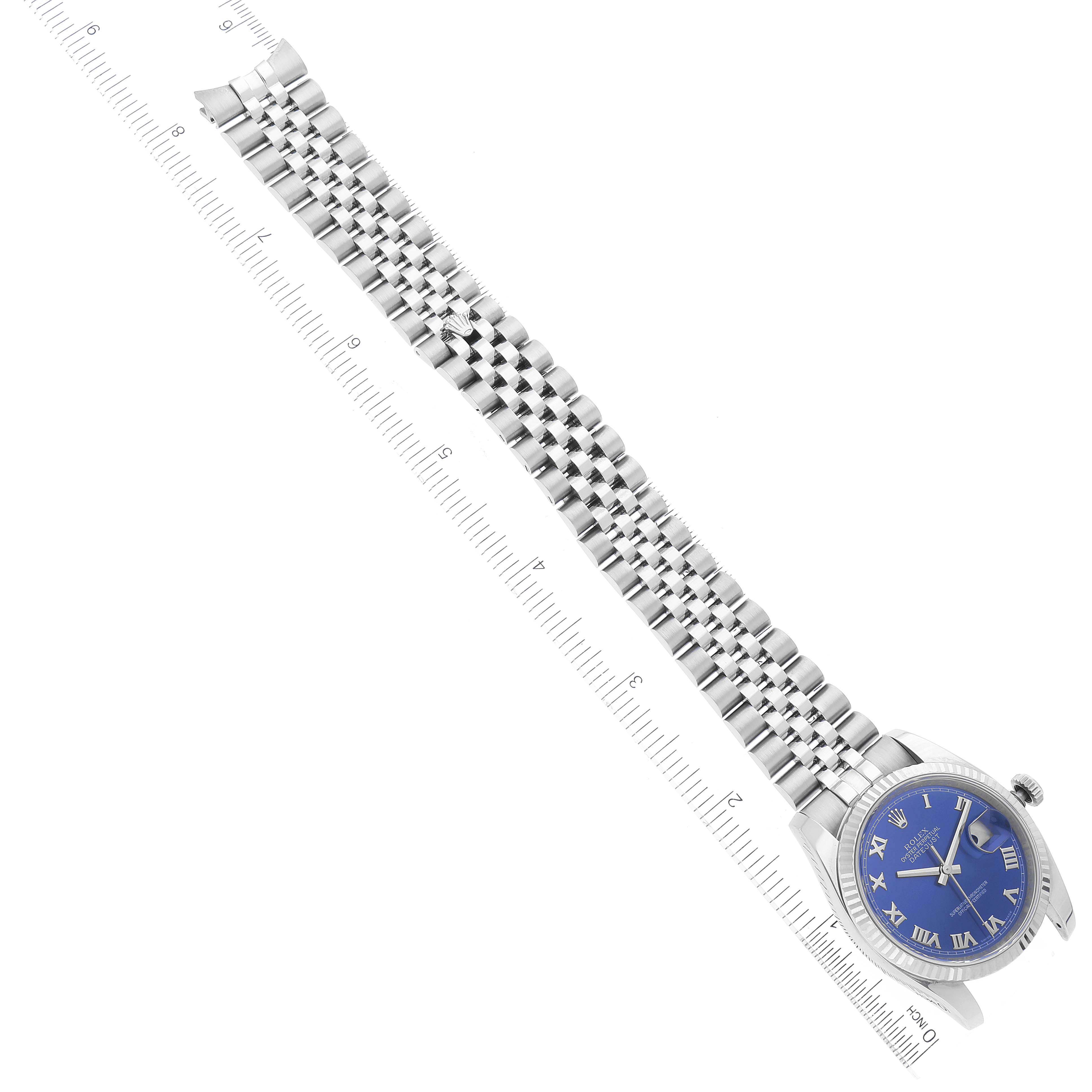The Rolex Datejust 116234 Men's Stainless Steel Blue Dial 116234 Men's Stainless Steel Blue Dial watch is shown from a top-down angle, featuring the face and full length of the bracelet, along with a ruler for scale.