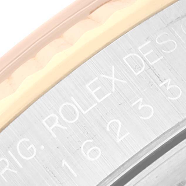 This image shows a close-up of the engraved side bezel of a Rolex Datejust 16233 Men's Steel and Gold (two tone) Champagne Dial 16233 Men's Steel and Gold (two tone) Champagne Dial watch.