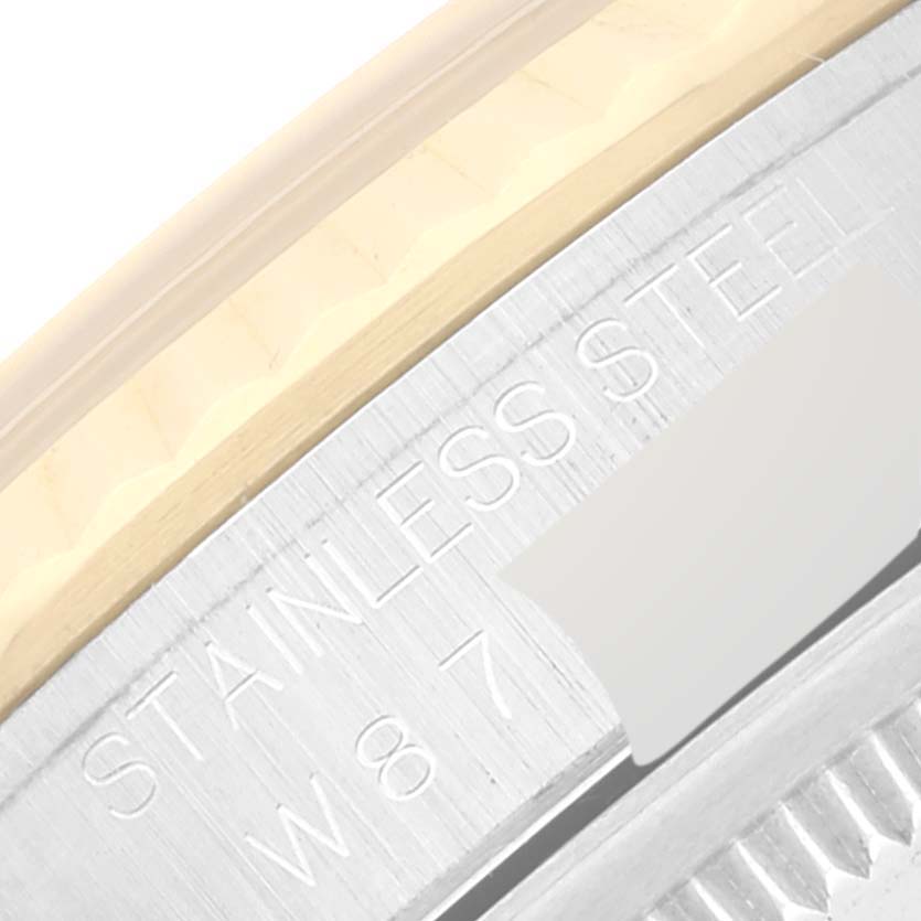 This image shows a close-up of the side of a Rolex Datejust 16233 Men's Steel and Gold (two tone) Champagne Dial 16233 Men's Steel and Gold (two tone) Champagne Dial watch, featuring the stainless steel and gold fluted bezel.