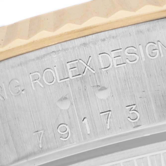 The image shows a close-up of the engraved bezel of a Rolex Datejust 79173 Women
s Steel and Gold (two tone) Black Dial 79173 Women
s Steel and Gold (two tone) Black Dial watch, highlighting the text details and serial number.
